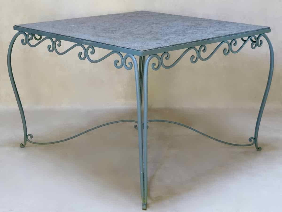 Elegant Art Deco square outdoor dining table. The wrought iron base is painted a delicate grey color. It has a scrolled apron, cabriole legs, and is joined by an pretty X-shaped stretcher. Dappled grey granite top.