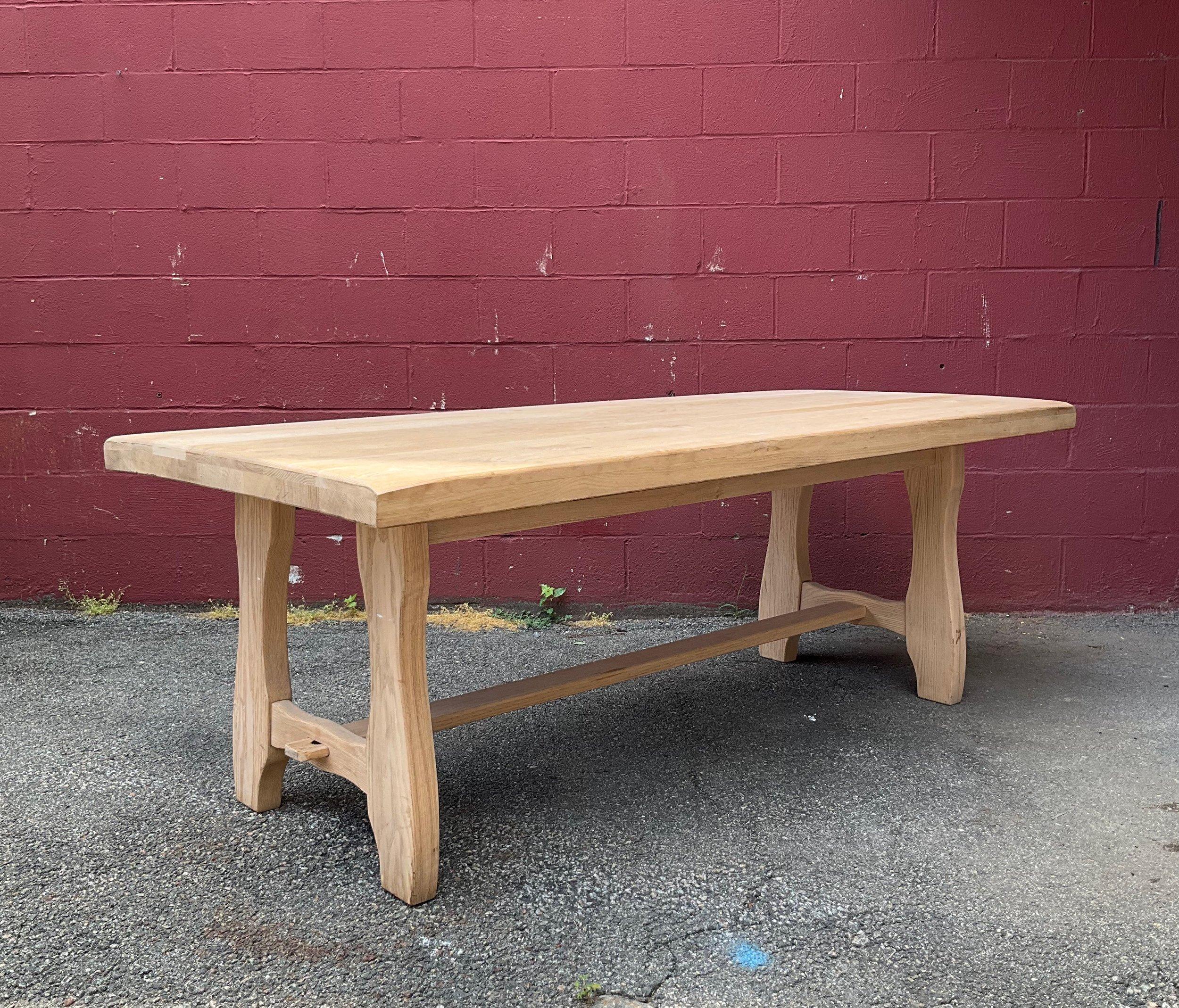 This large 1950s French monastery style library or hall table with a lower stretcher is a stunning piece of furniture that possesses both elegance and simplicity. Featuring a solid plank top, the table is designed to offer maximum stability and