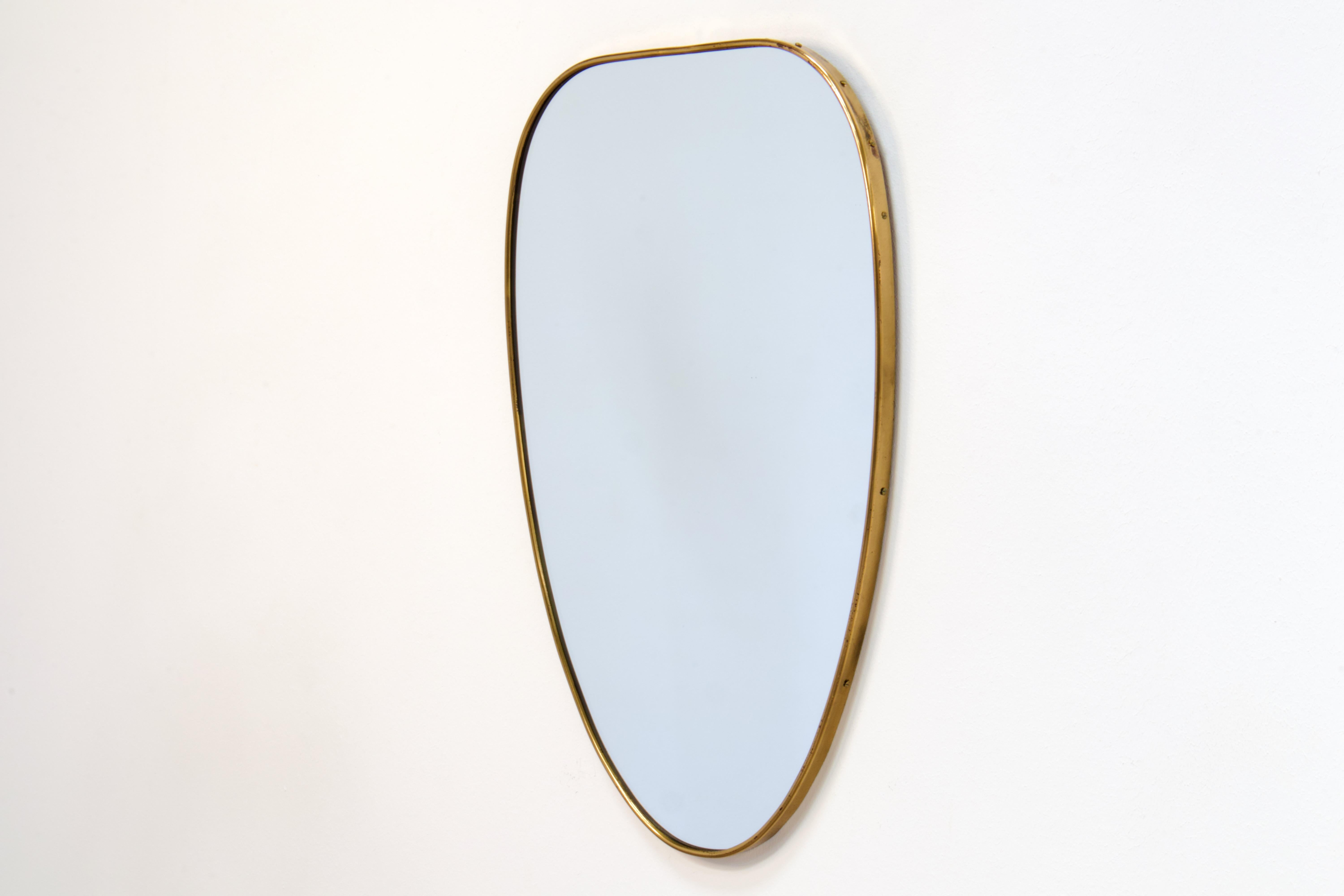 Miroir mural en laiton patiné d'époque Gio Ponti. Fabriqué en Italie dans les années 1950.

La forme du miroir est un ovale très élégant aux angles arrondis et à la belle conicité. La partie supérieure est plus large et se rétrécit jusqu'à la partie
