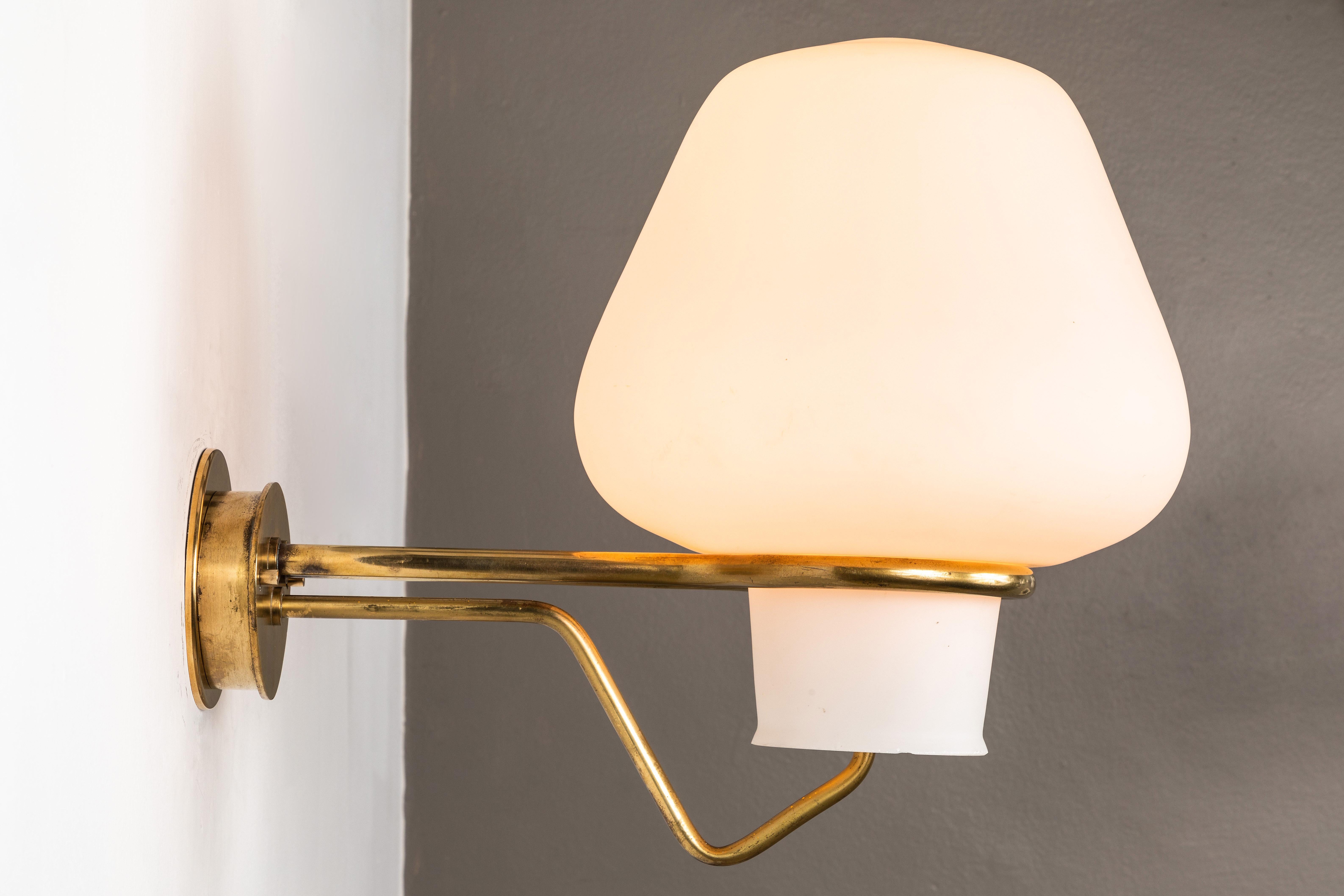 Large 1950s Gunnar Asplund JH-813 brass and glass sconce for ASEA. Executed in brass and opaline glass. A uniquely architectural and rare Swedish lamp that when illuminated casts a warm and beautiful glow.

Professionally rewired by UL authorized