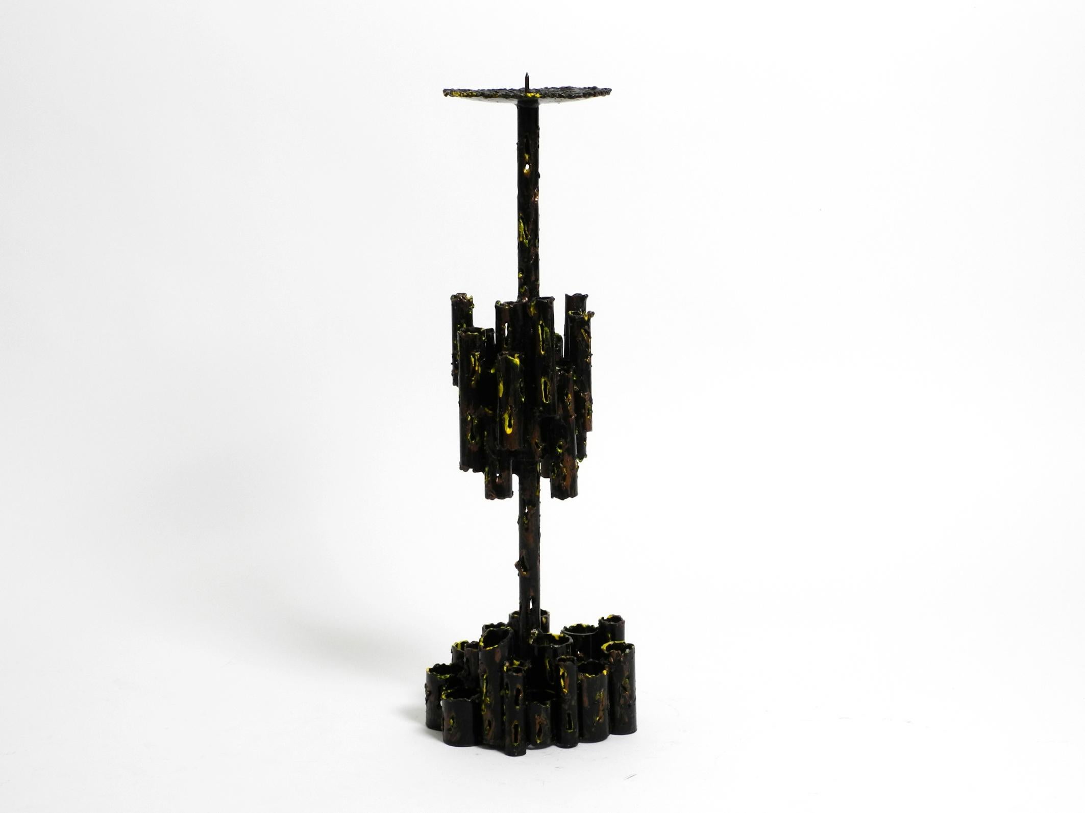 Large 1950s heavy sculptural brutalist iron candlestick by Marcello Fantoni. Made in Italy.
Great sculptural design made of black iron pipes in various lengths, painted in light brown and small yellow paint details.
No damage to the candlestick. No