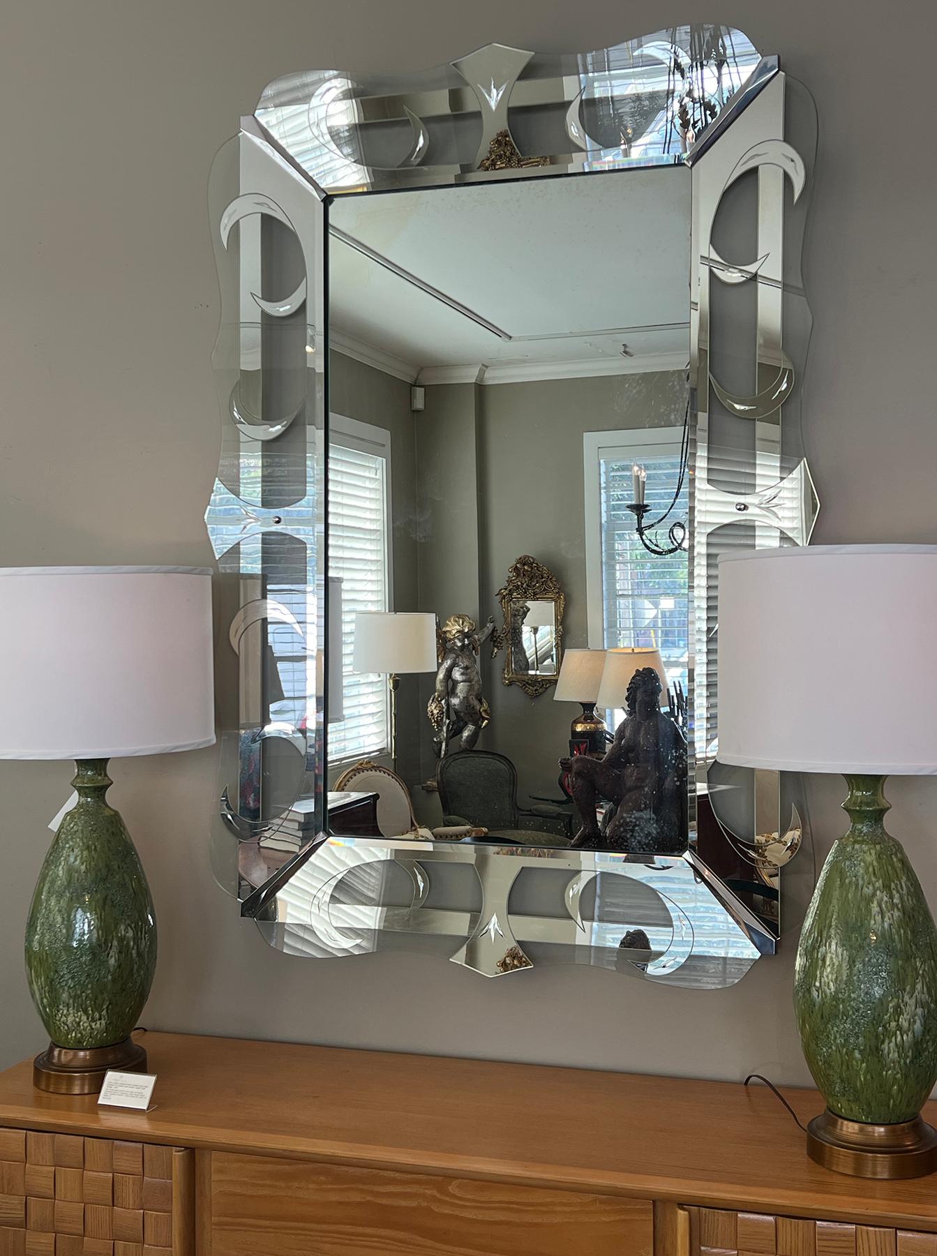 Splendido specchio da parete Hollywood Regency di metà secolo, datato gennaio 1956 sul retro; l'alta lastra rettangolare dello specchio è inserita in un'eccezionale cornice ondulata di vetro trasparente e acidato con supporti cromati ad ogni angolo.