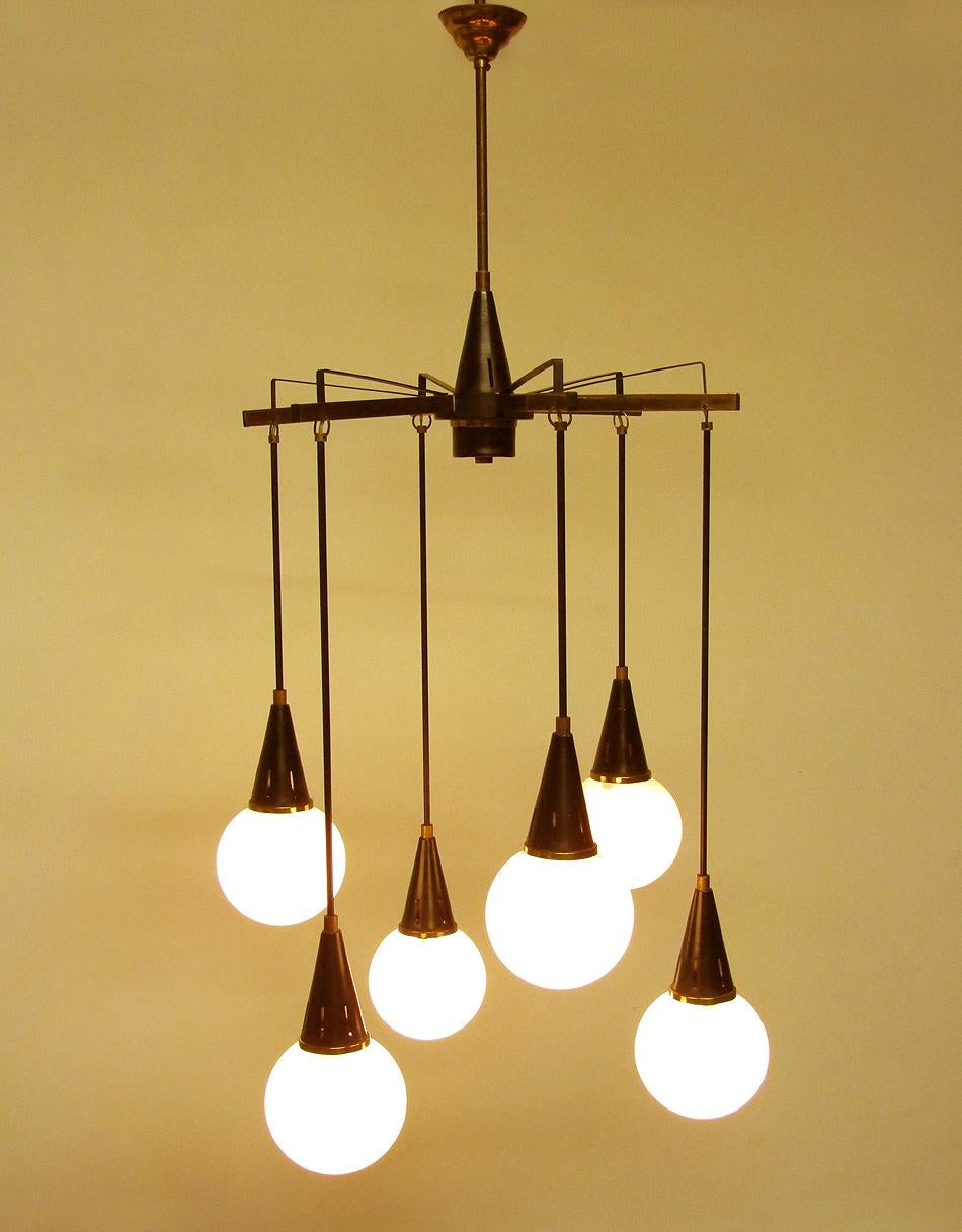 A large, vintage 1950s six-light hanging chandelie in the style of Stilnovo. 

In a combination of glass, brass and black enameled steel, the globe shades hang from steel rods, which are suspended from brass arms.

With an impressive height of