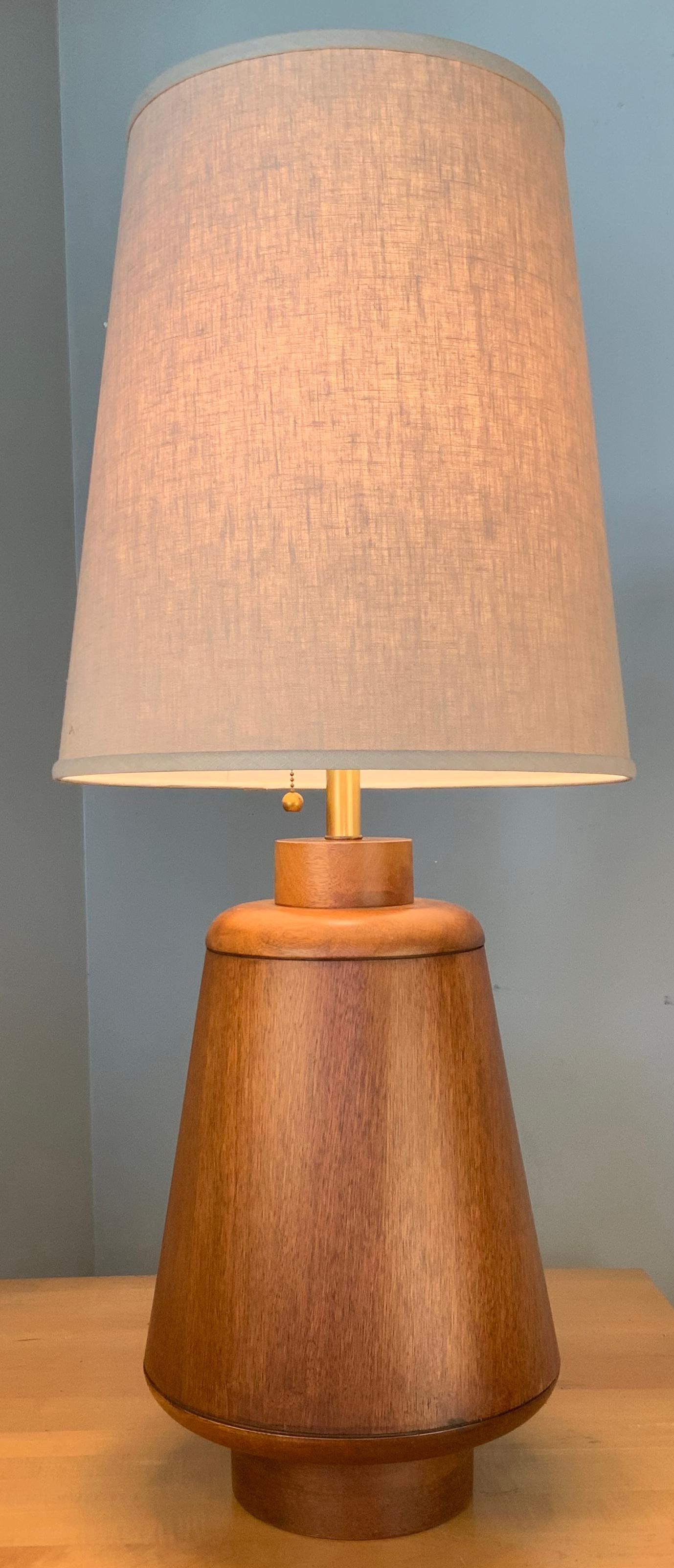 a wonderful large scale 1950s walnut table lamp, with a large round tapered base. beautiful scale and proportions, along with a tapered linen lampshade.
