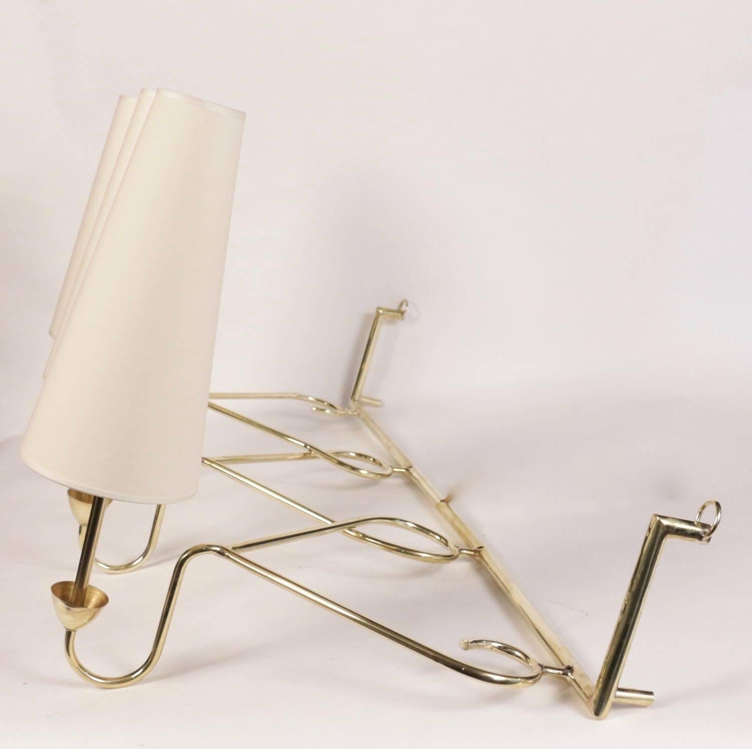 Large 1950s sconce House Stilnovo Style.

Nice curved brass work. Each sconce's base underlined with a brass cup.
Three lighted arms surmounted by custom lampshades.
