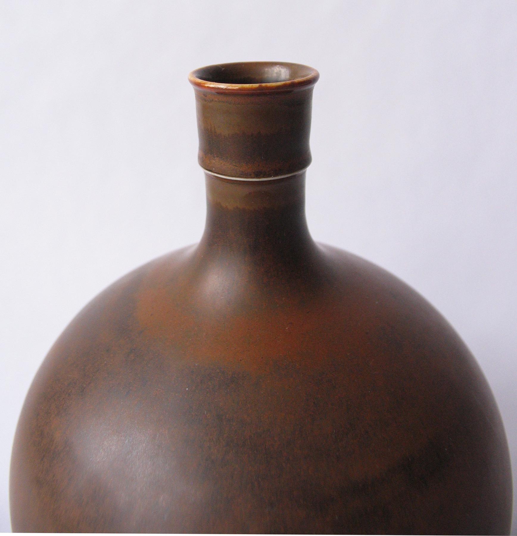 Large elegant stoneware vase by Stig Lindberg for Gustavsberg, Sweden, circa 1950s.
Beautiful brown hairsfur glazed bottle form. Signed on bottom.