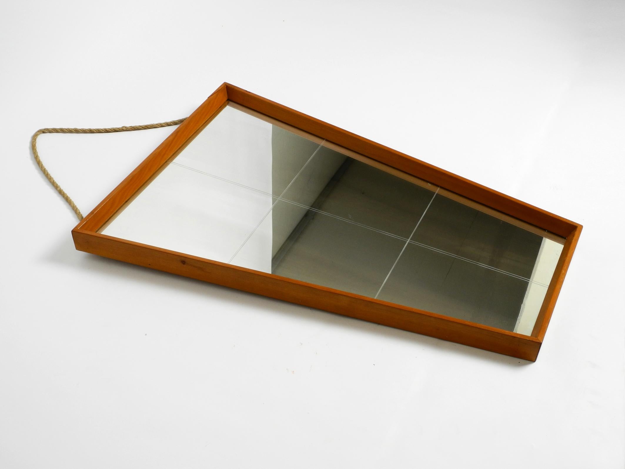 Beautiful large Mid Century wall mirror in trapezoidal shape.
Frame is made of solid wide high-quality cherry wood. With thick rope for hanging.
You can also hang the mirror without the rope.
The hooks are original and still on the back.
Great