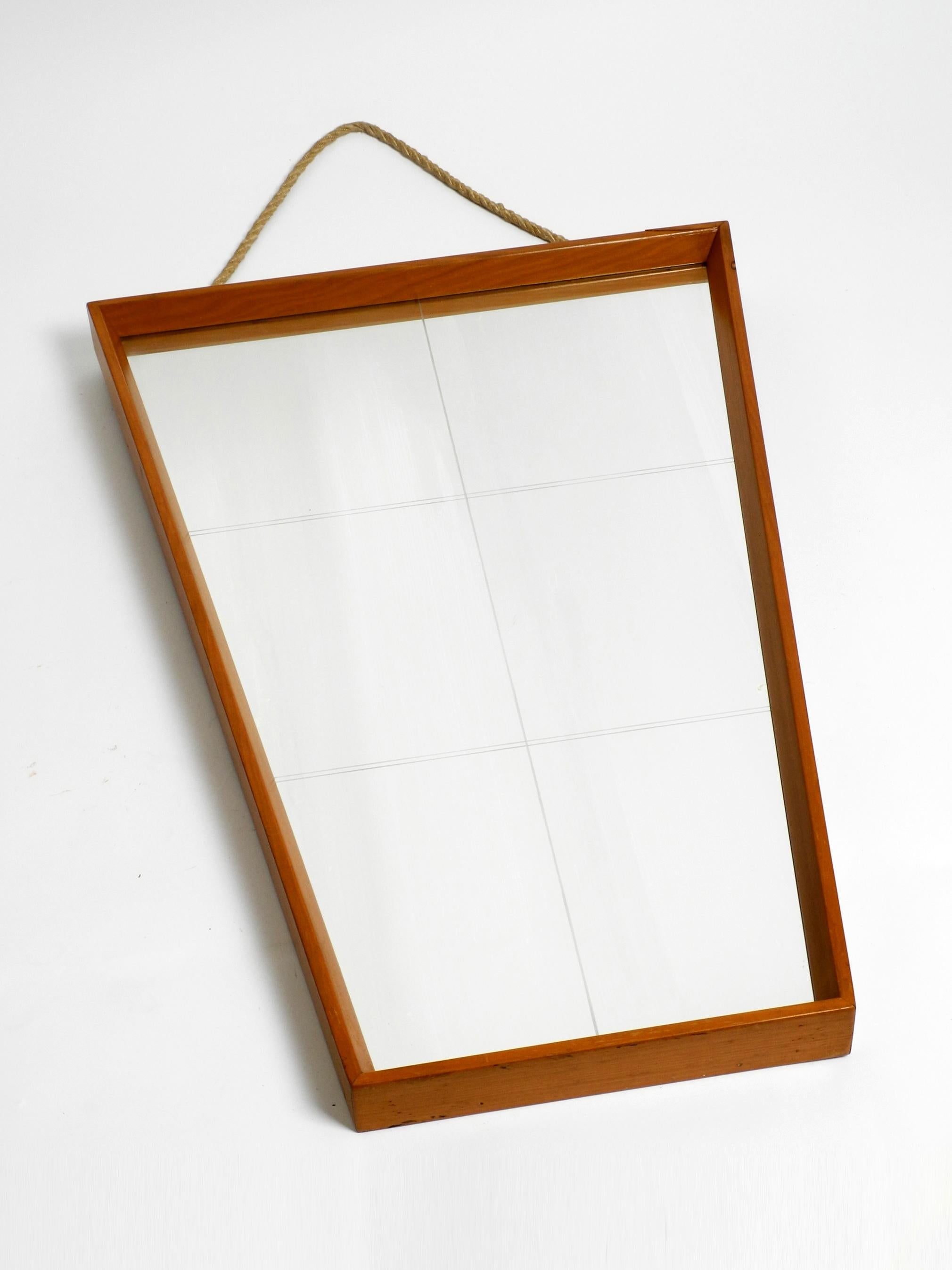 German Large 1950s wall mirror in trapezoidal shape with a solid cherry wood frame For Sale