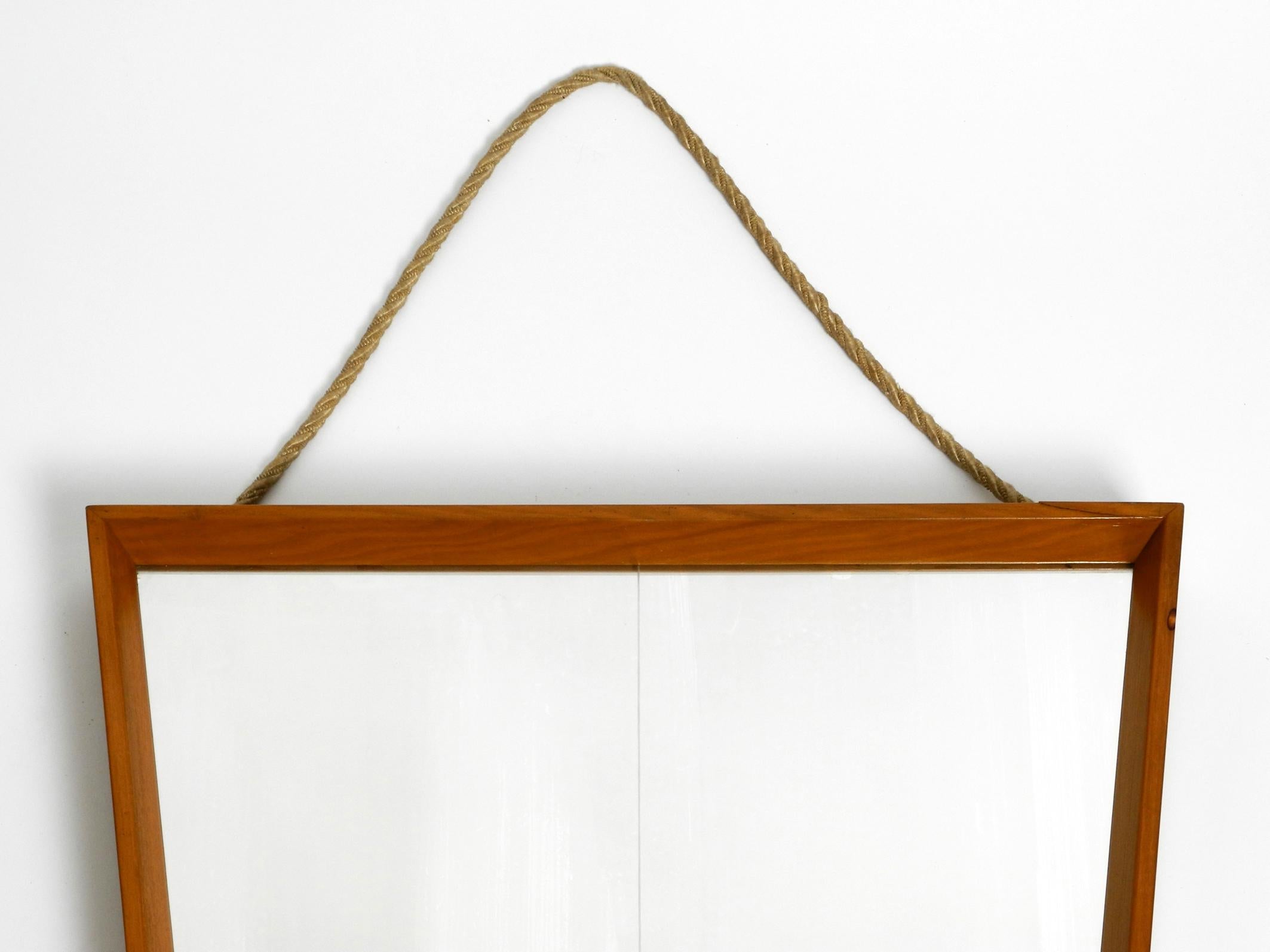 Mirror Large 1950s wall mirror in trapezoidal shape with a solid cherry wood frame For Sale