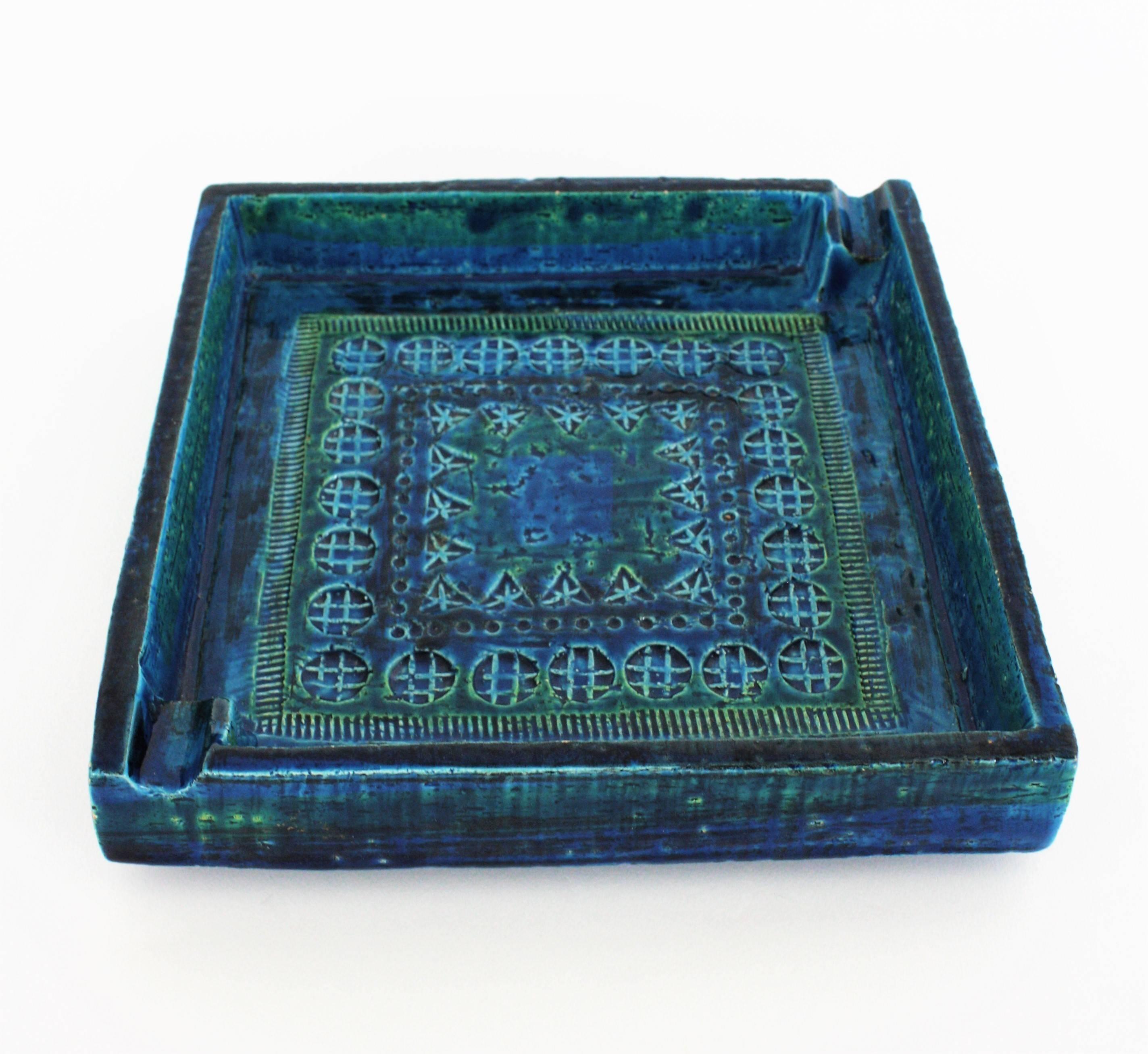 Large Rimini blue, blue glazed terracotta ceramic ashtray design by Aldo Londi and manufactured by Bitossi. Handcrafted in Italy with hand-carved geometric design and in a glazed vibrant turquoise and cobalt blue. It has two cigarette holders at the