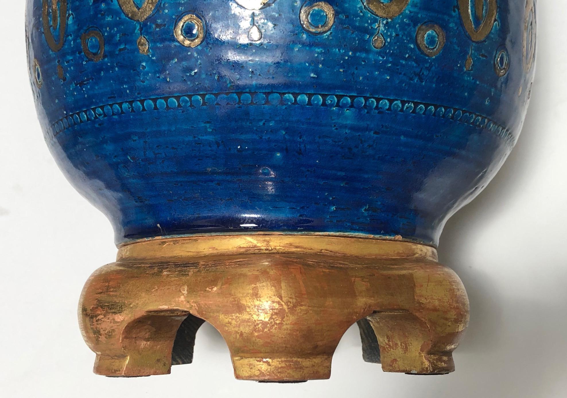 La lampe en forme d'urne est d'une taille impressionnante avec un décor de gouttes d'eau dorées sur un fond céruléen profond ; elle repose sur une base en bois doré personnalisée et sculptée à la main ; hauteur 23
