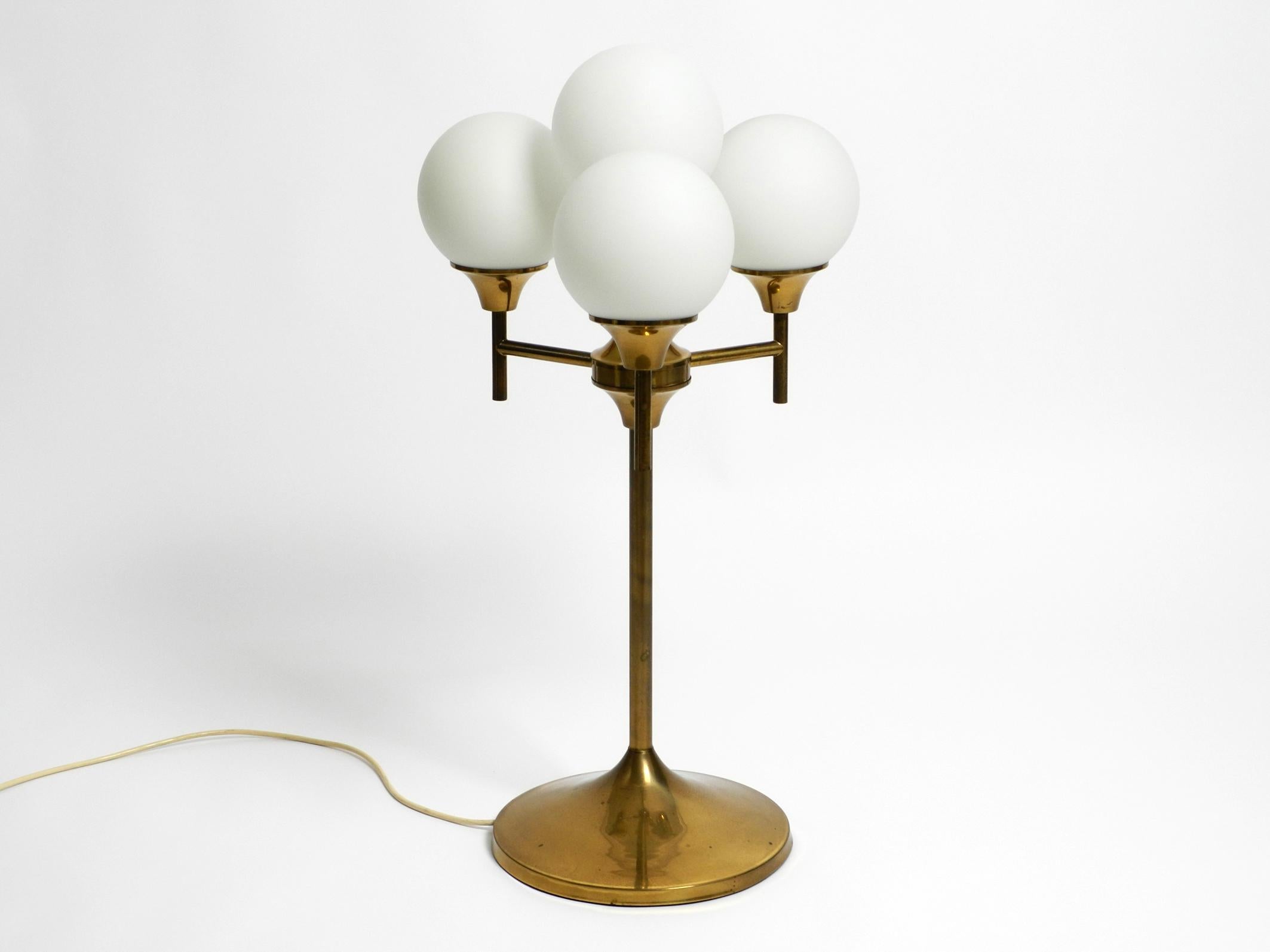 Extraordinary beautiful large 1960s heavy brass table or floor lamp.
Manufacturer is Kaiser Leuchten. Made in Germany.
Lampshades are made of 4 white frosted glass spheres. Makes a very nice soft light.
Great Mid Century Space Age design with many