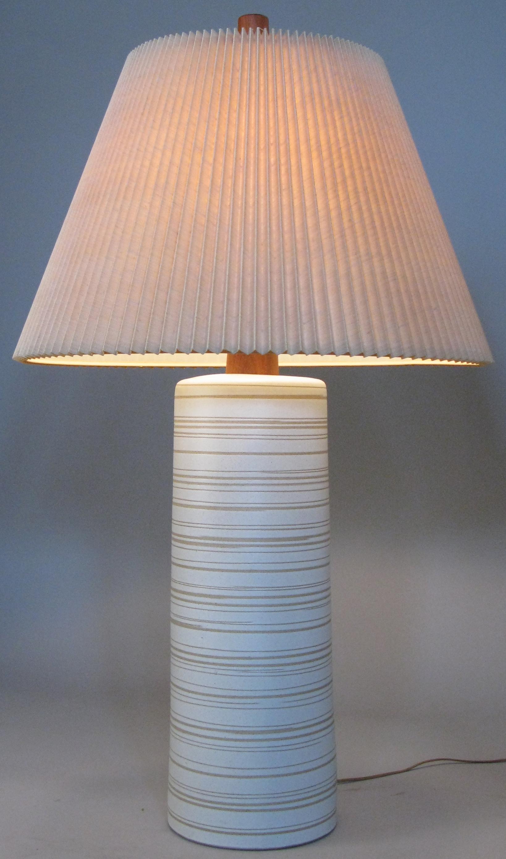 A very large vintage 1960s glazed ceramic table lamp by Gordon Martz for Marshall Studios, with a walnut neck and the original walnut finial. The lamp is off white with grey and taupe colored details. The linen pleated shade may also be original to