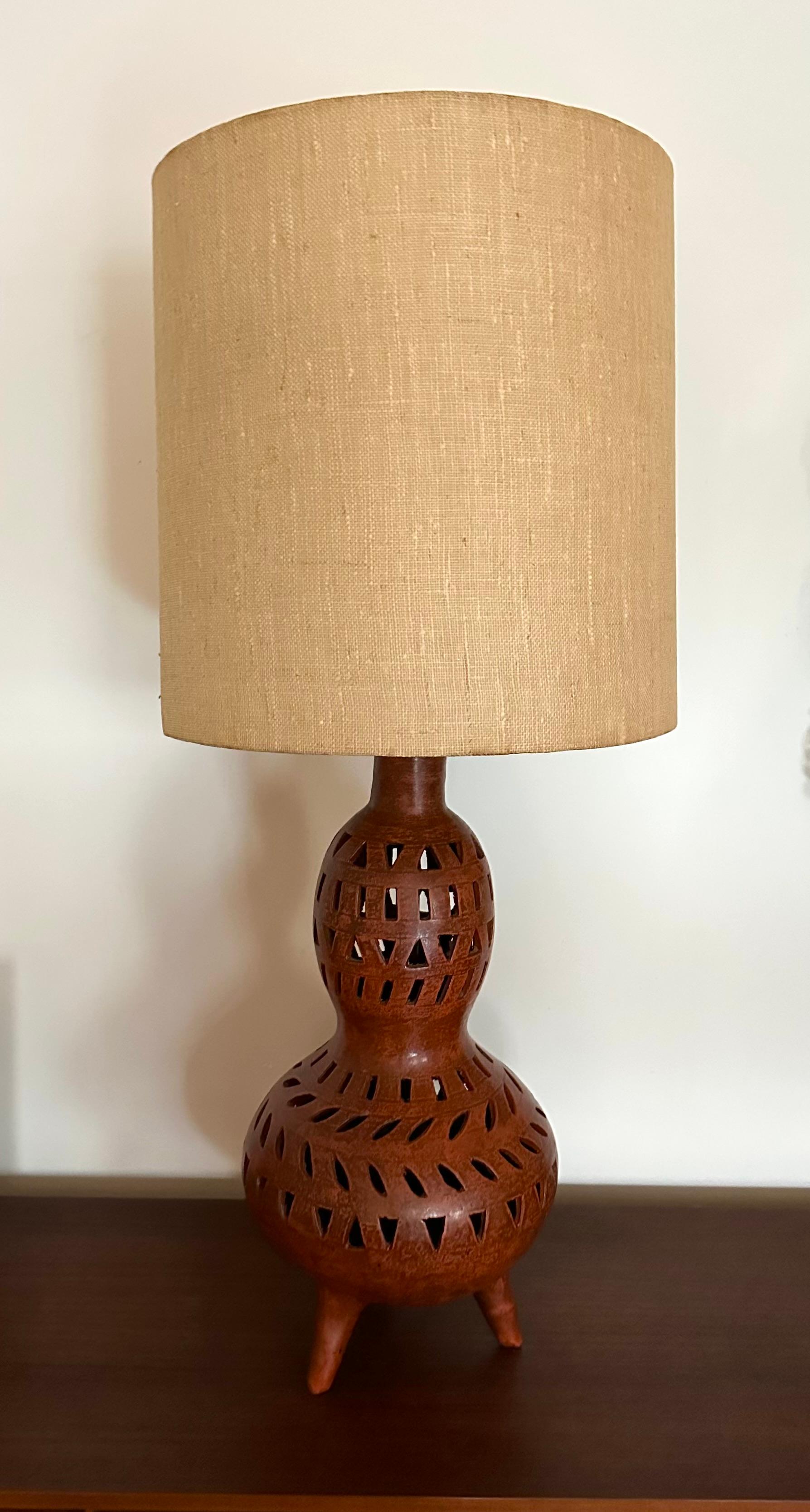 Large sculptural organic modern table lamp. The hand built gourd-shaped body decorated with cutout designs.  The pottery base measures 23