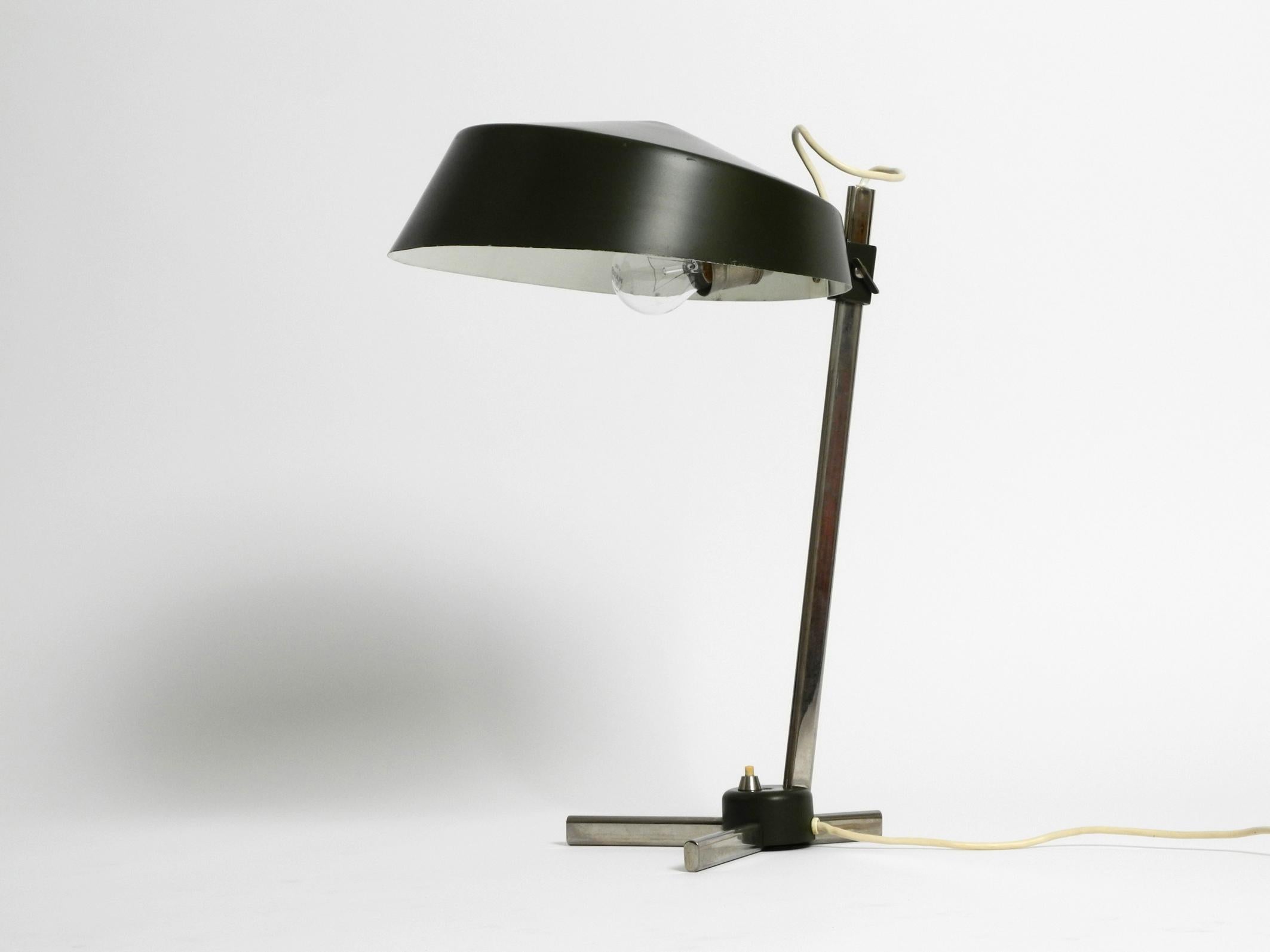 High quality 1960s Industrial table lamp with height-adjustable shade. 
Great rare Industrial Design. Made in Germany.
The shade is steplessly adjustable in height and holds firmly in any position.
Shade and foot are covered with the original