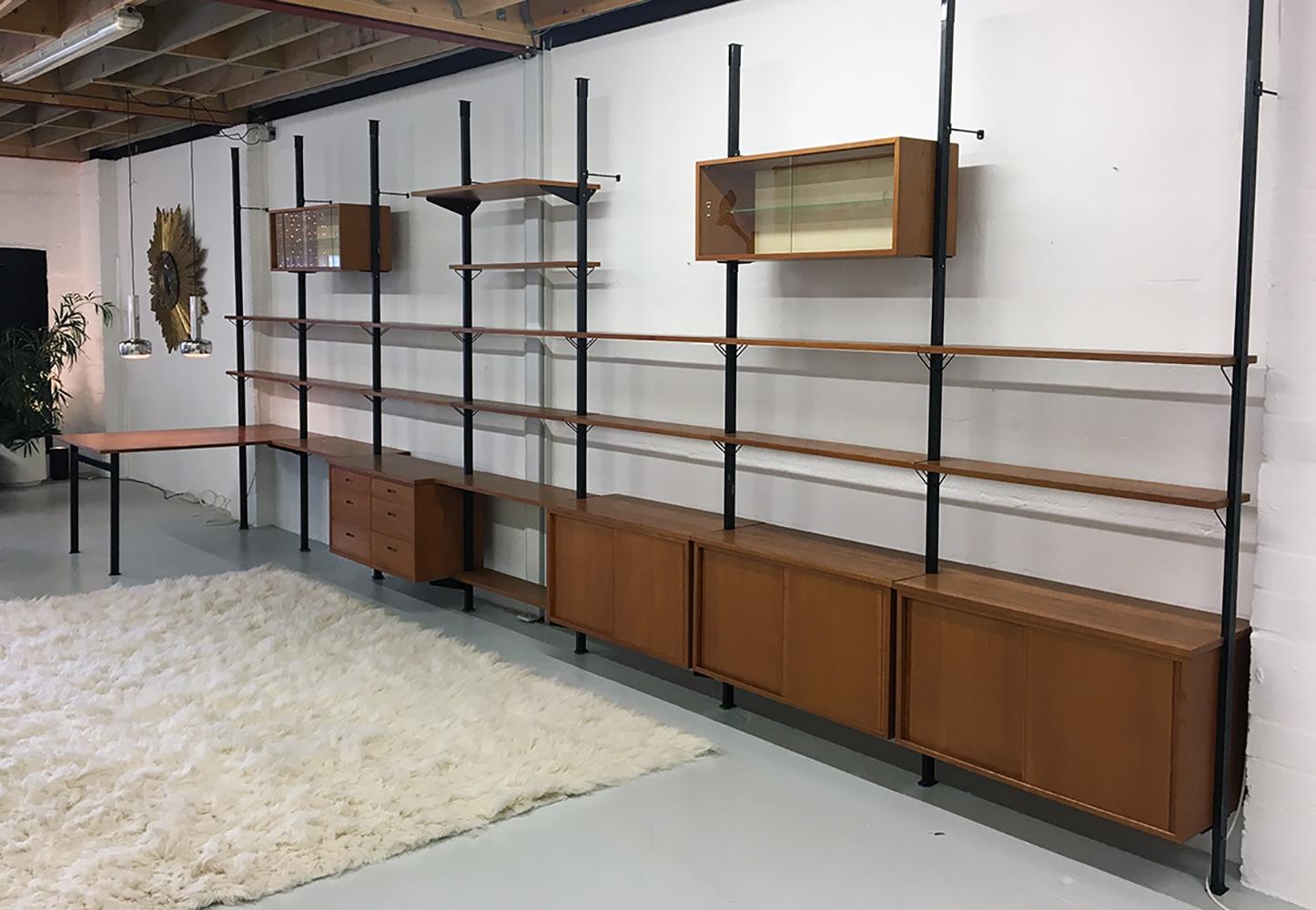 A large run of 1960s modular shelving system ‘Pira’ designed by Olaf Pira for string of Sweden, made of teak and steel.
Designed as a ‘tension’ system where each upright is trapped between the floor and ceiling eliminating the need for wall