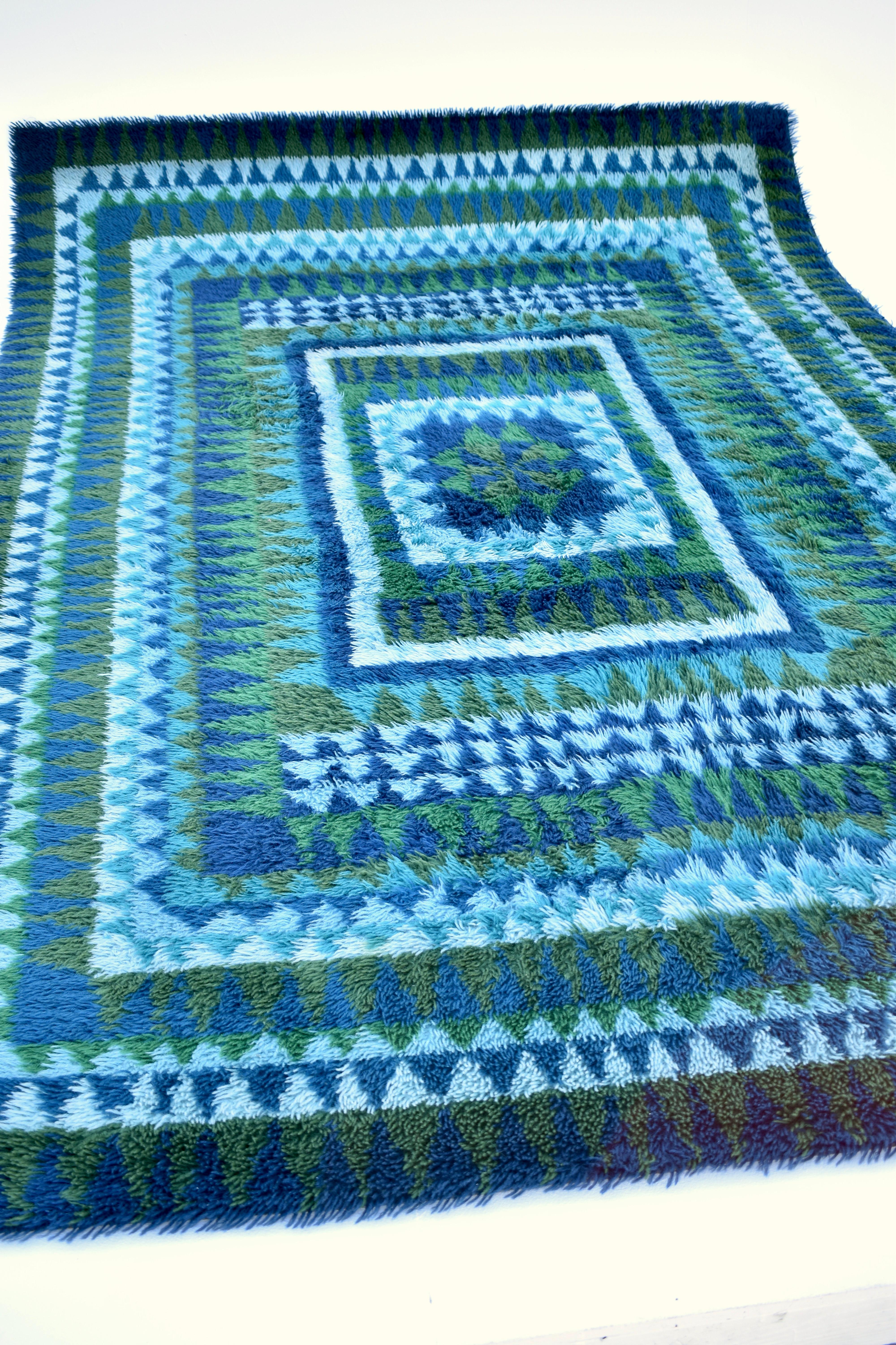 A large and outstanding handmade wool Rya rug from the 60’s with a very pleasing patern and colour pallete of forrest greens and aqua blues. Very unusual to find such a fine quality rug of this size in such beautiful condition.

This would make an