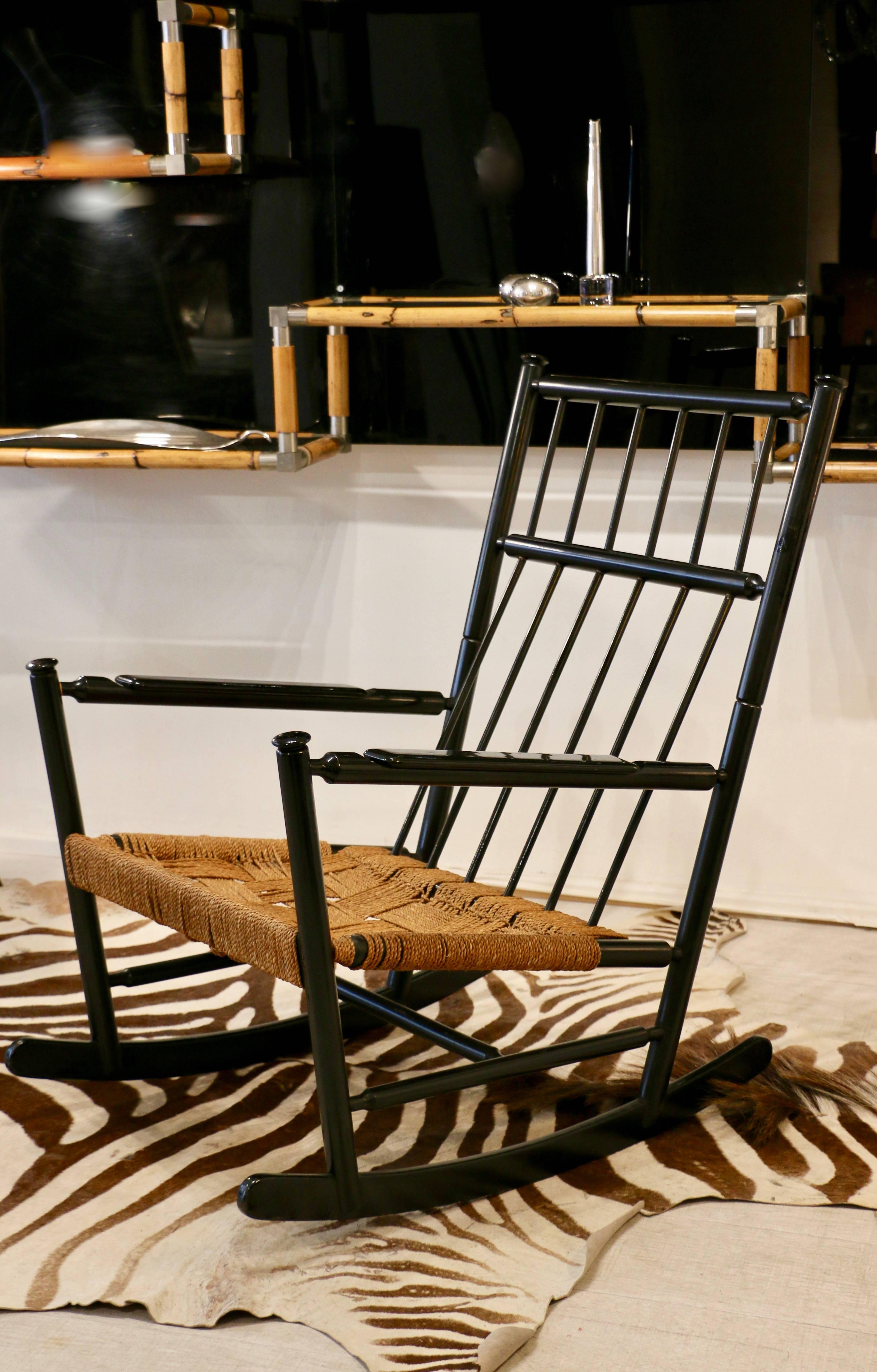 1960s, Scandinavia, a large rocking chair in black wood. Seat of origin in braided rope.
 