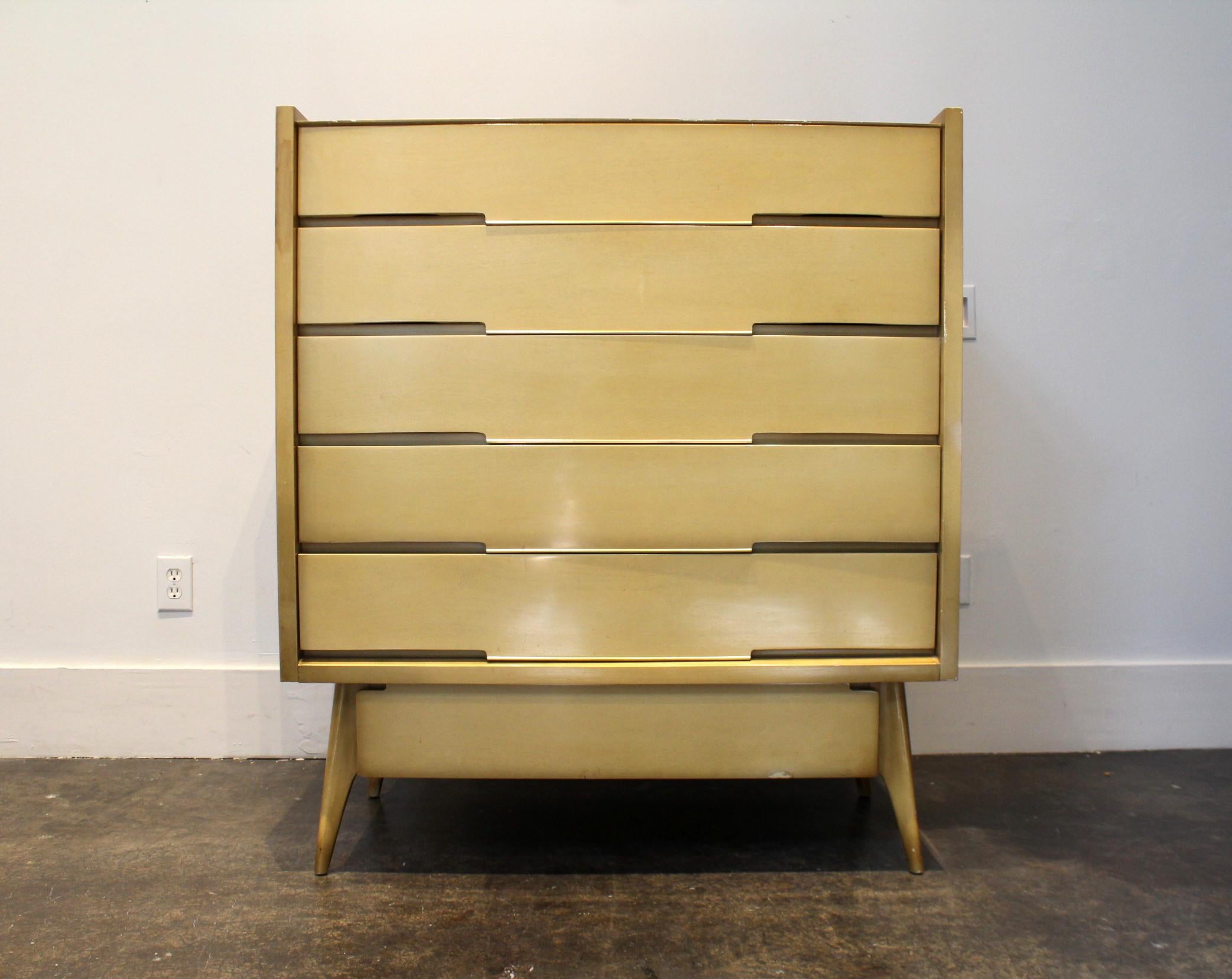 Large sculptural high chest in maple-colored wood with gold tones on the edges. Six total drawers, each with thin brass pulls. Piece is from 1963, has a worn out label on back for 