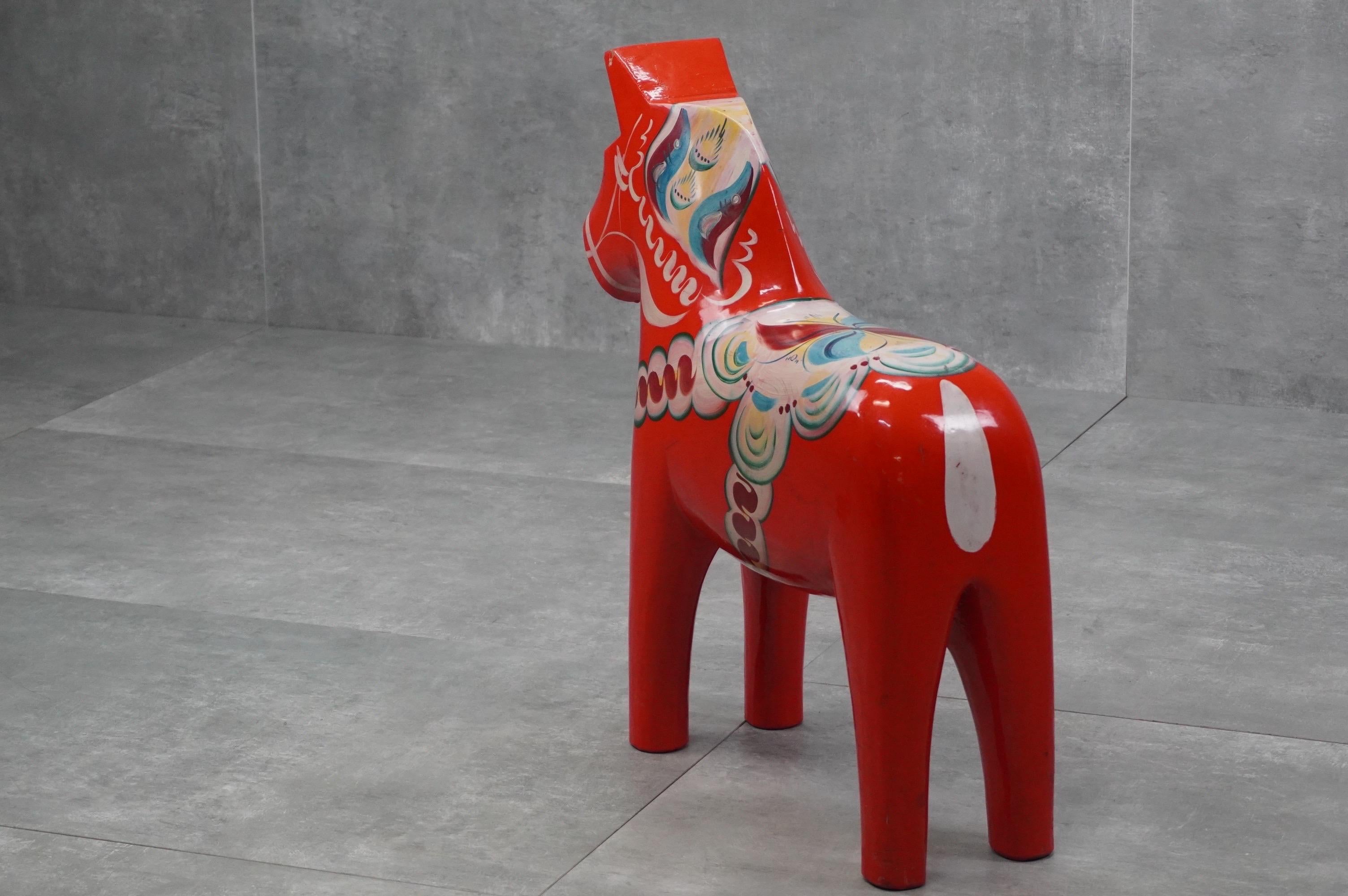 Iconic Scandinavian piece: a large wooden Dala horse, hand-painted in vivid red by Nils Olsson in Sweden, 1960s. A joyful decorative object with cultural significance.