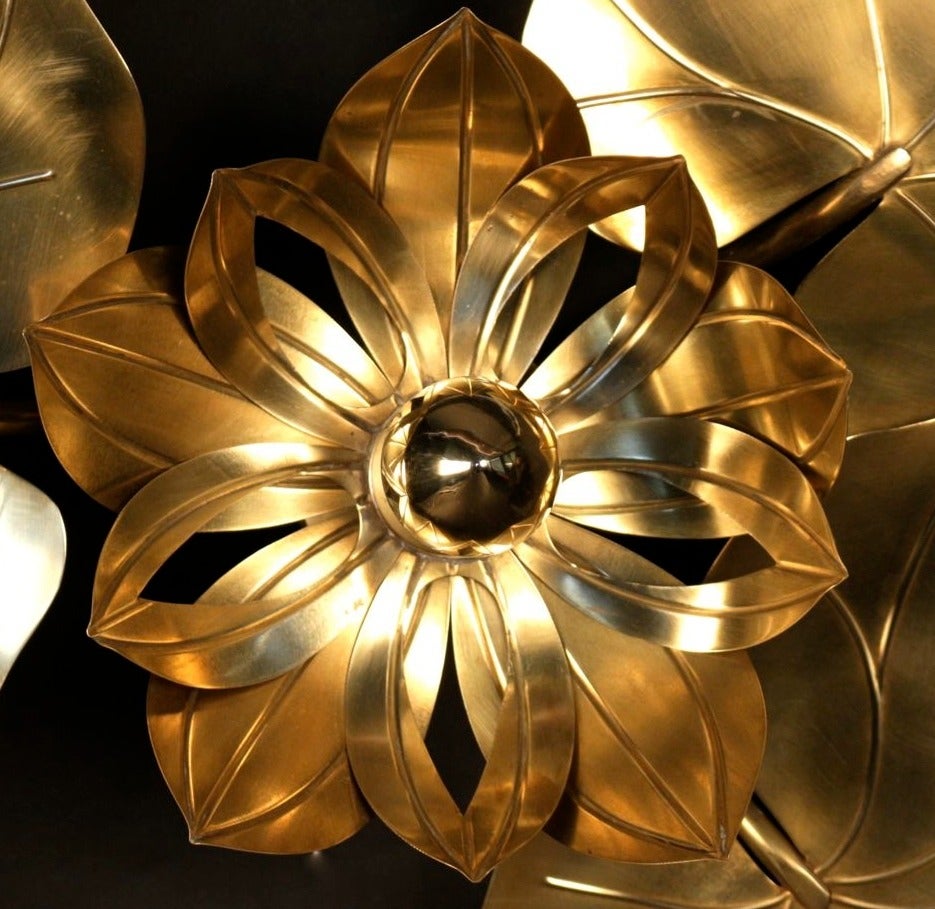 Large 1960s 'Waterlily' vegetal sconce. Composed of three gilt brass leaves. Behind each leave a light source. In the center, a large waterlily flower whose pistil is replaced by a gilt cap bulb enhanced with two rows of petals. Four-light sources.