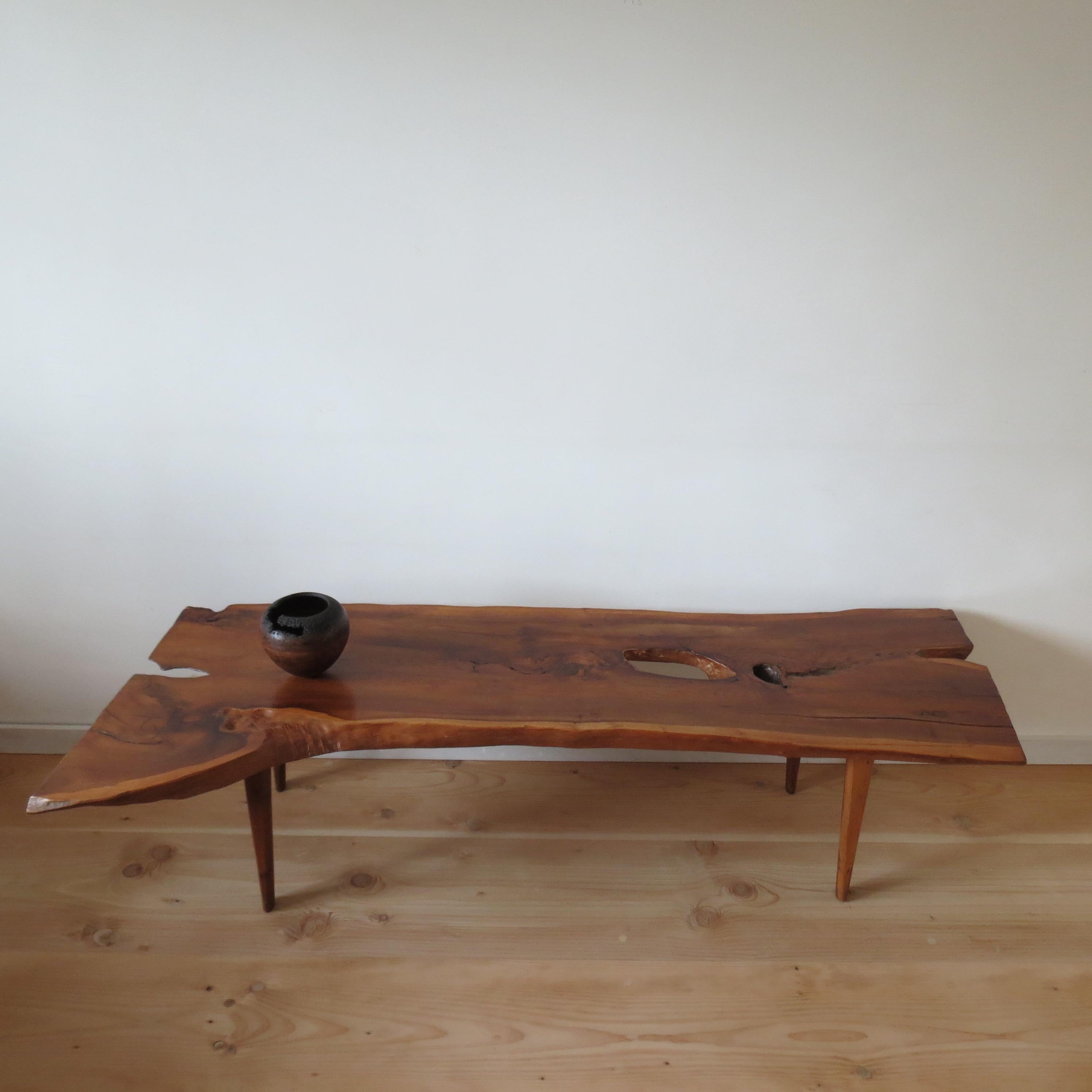 Wonderful coffee table made from solid Yew Wood. Good quality piece with very nicely shaped legs and waney edged top. Great over all colour. The table dates from the 1960s and is in good vintage condition. A plaque to the underside reads N H Chapman