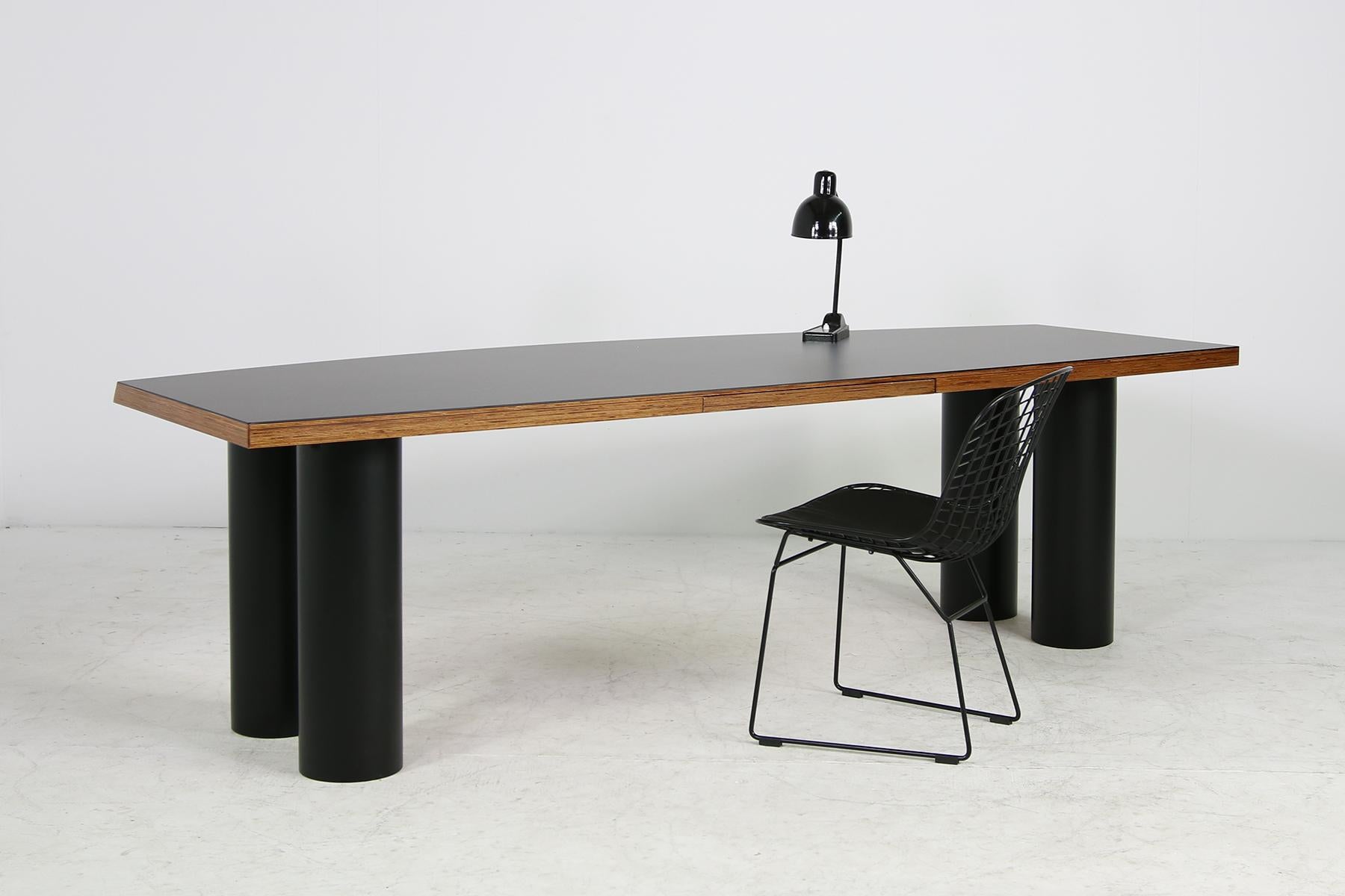 Beautiful and unique 1970s architect's design writing table, made of heavy weight solid plywood, the columns are made of hard polyvinyl, very sturdy material, the desk surface is covered with black matte formica, under this a light wooden structure