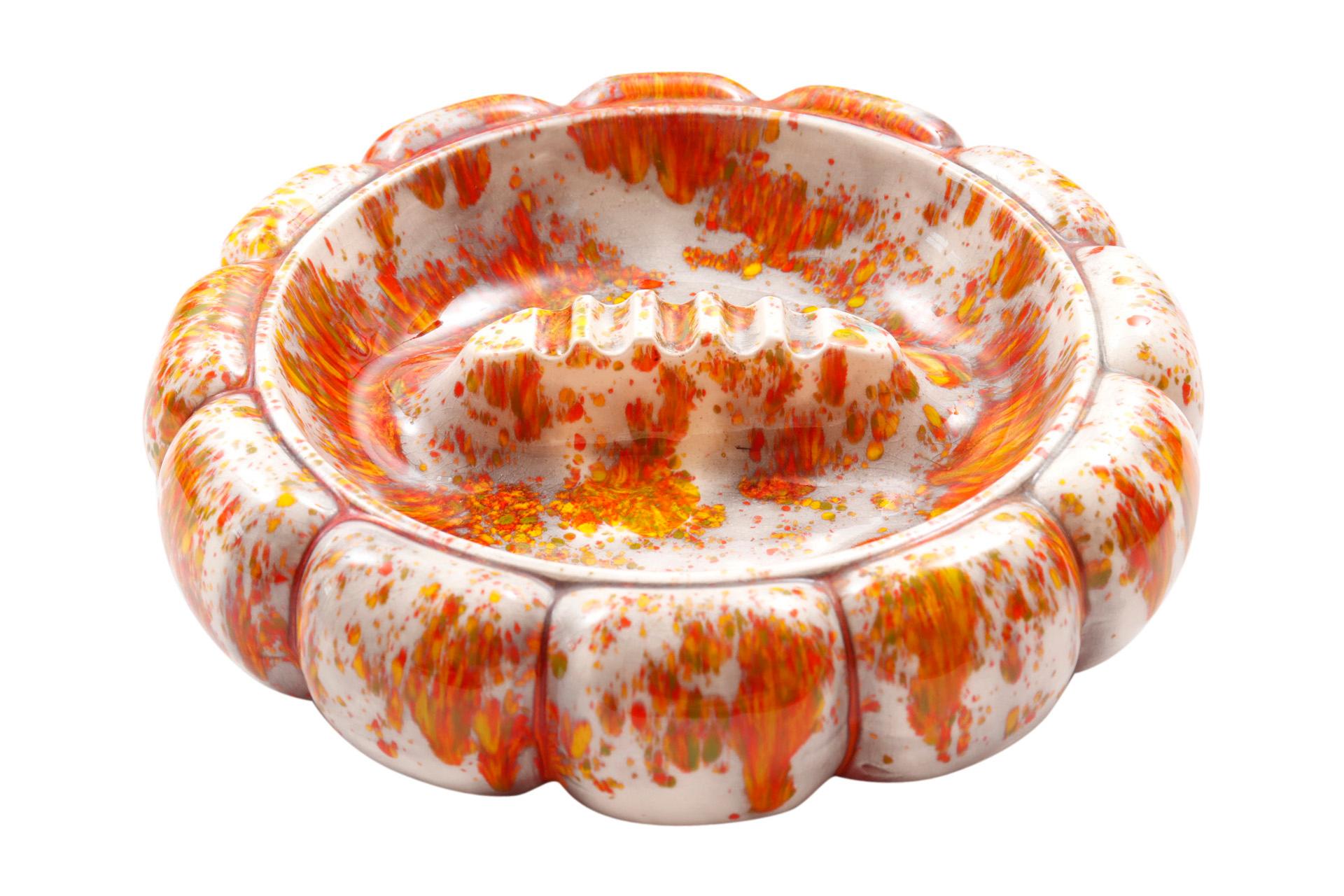 A pair of large round ceramic ashtrays glazed in bright red, orange and white. Bubble shaped edges give the look of gourds. At the center is a raised cigarette rest. Mold mark reads Arnels. Hand inscribed underneath Liz 76 and Liz 77. Dimensions per