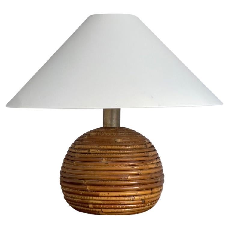 Generously scaled table lamp from Italy 1970s. Hand-woven rattan and brass top.