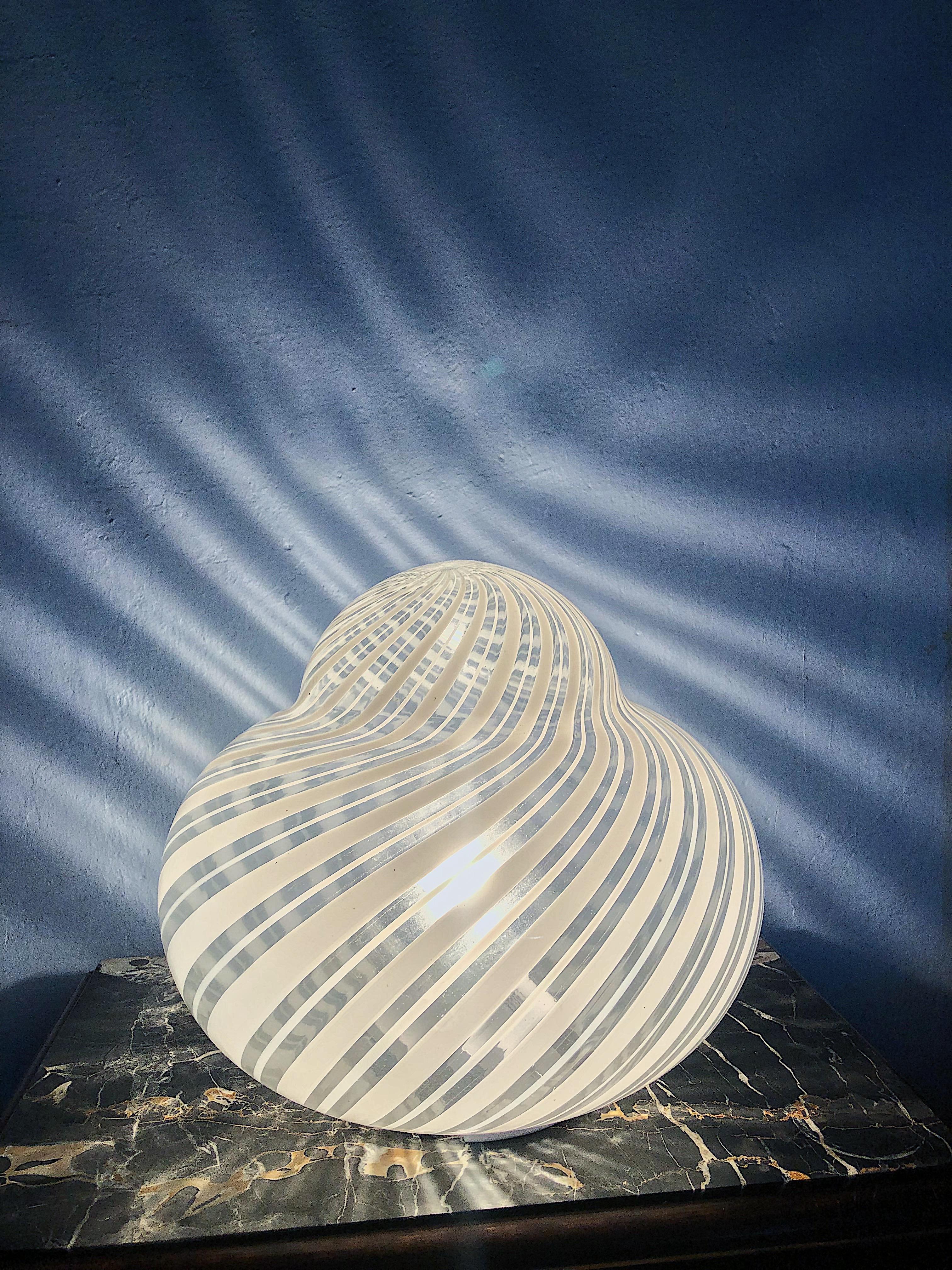 Large white Murano glass swirl lamp. Suitable for table or as a floor light.
Creator: F.FABBIAN Murano

Dimensions: Height: 30 cm Diameter: 33 cm
Materials and Techniques: Metal, Glass
Place of Origin: Italy
Period: 1970-1980
Condition: Mint