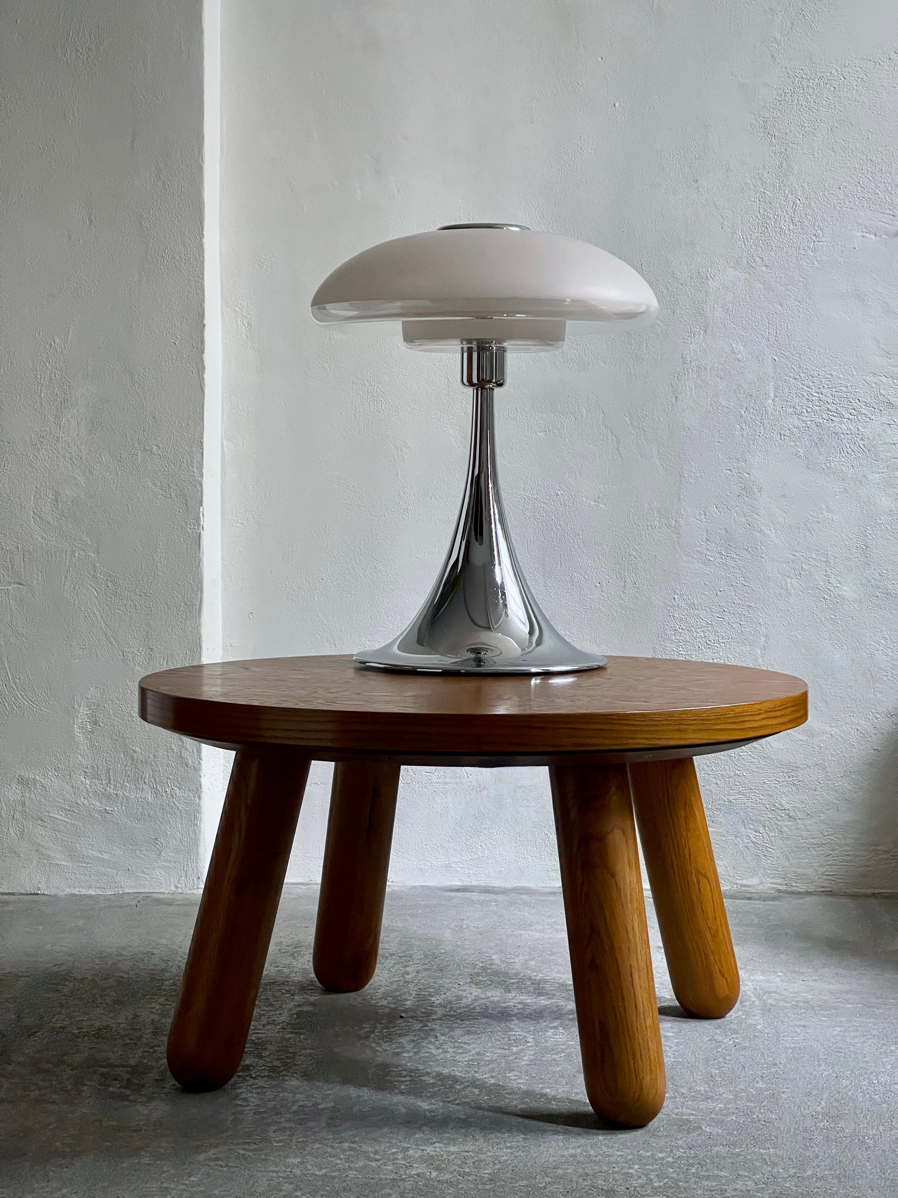 La rare et grande lampe de table VP Europa de Verner Panton, datant des années 1970, est un élément de l'histoire du design qui marie harmonieusement la forme et la fonction. Son abat-jour en verre opalin, sa base chromée et son esthétique de l'ère