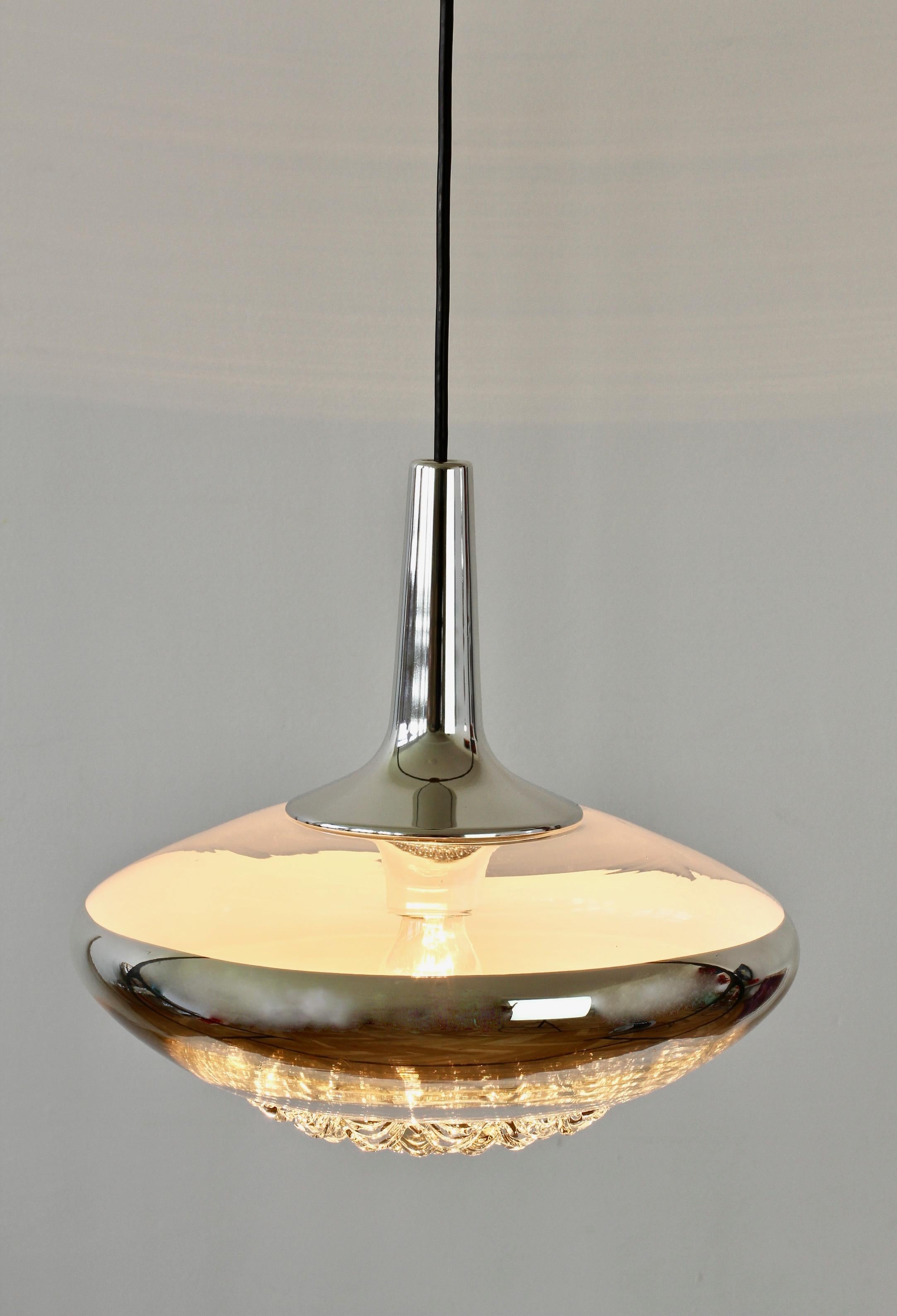 Vintage midcentury pendant light by German lighting manufacture Peill & Putzler in the late 1970s. This is an absolutely Classic piece of design, featuring a clear textured glass shade with an applied silver chrome colored band, on the inside of the