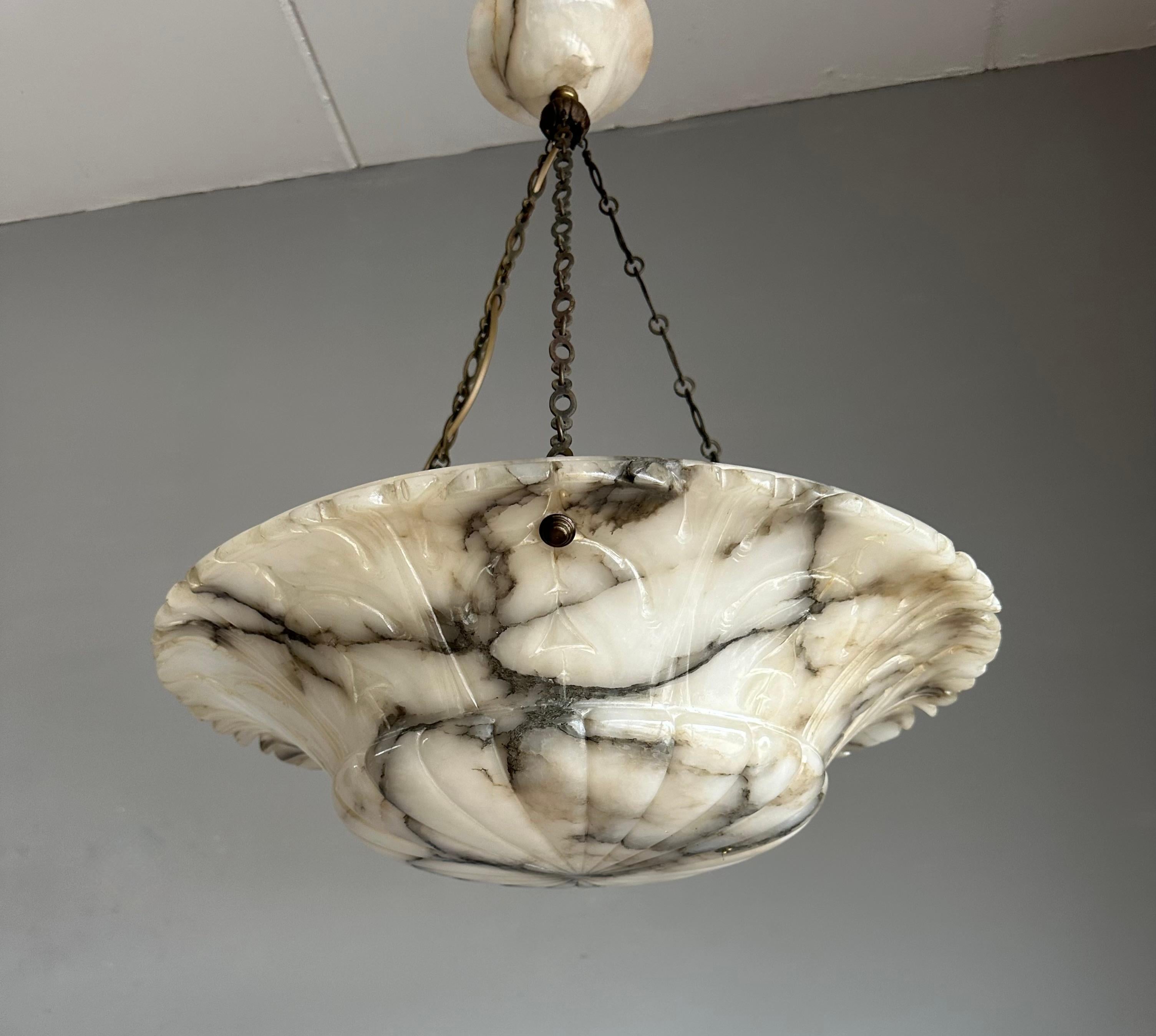 Lustre antique de grande classe avec un abat-jour à motifs de feuilles sculptées à la main et un baldaquin parfaitement assorti.

Grâce à sa grande taille et à son superbe état, ce lustre en albâtre à trois lumières illuminera aussi bien vos