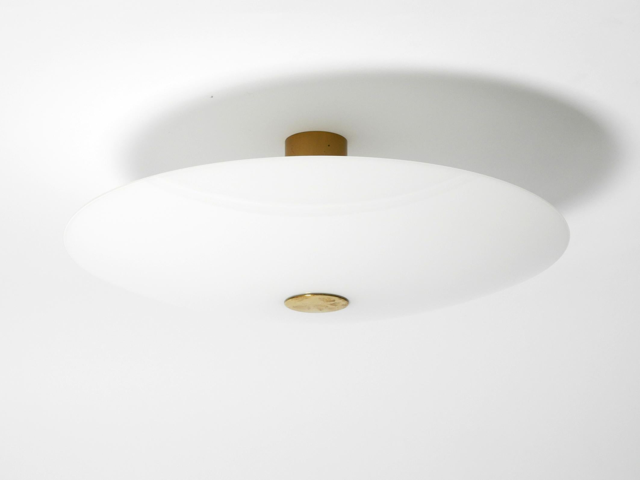Gran lámpara de techo redonda Florian Schulz, Gela 55, años 80.
La Gela 55 también puede montarse en la pared como aplique.
Con pantalla de cristal opalino. El marco es de latón macizo y pesado.
Precioso diseño minimalista en muy buen estado vintage