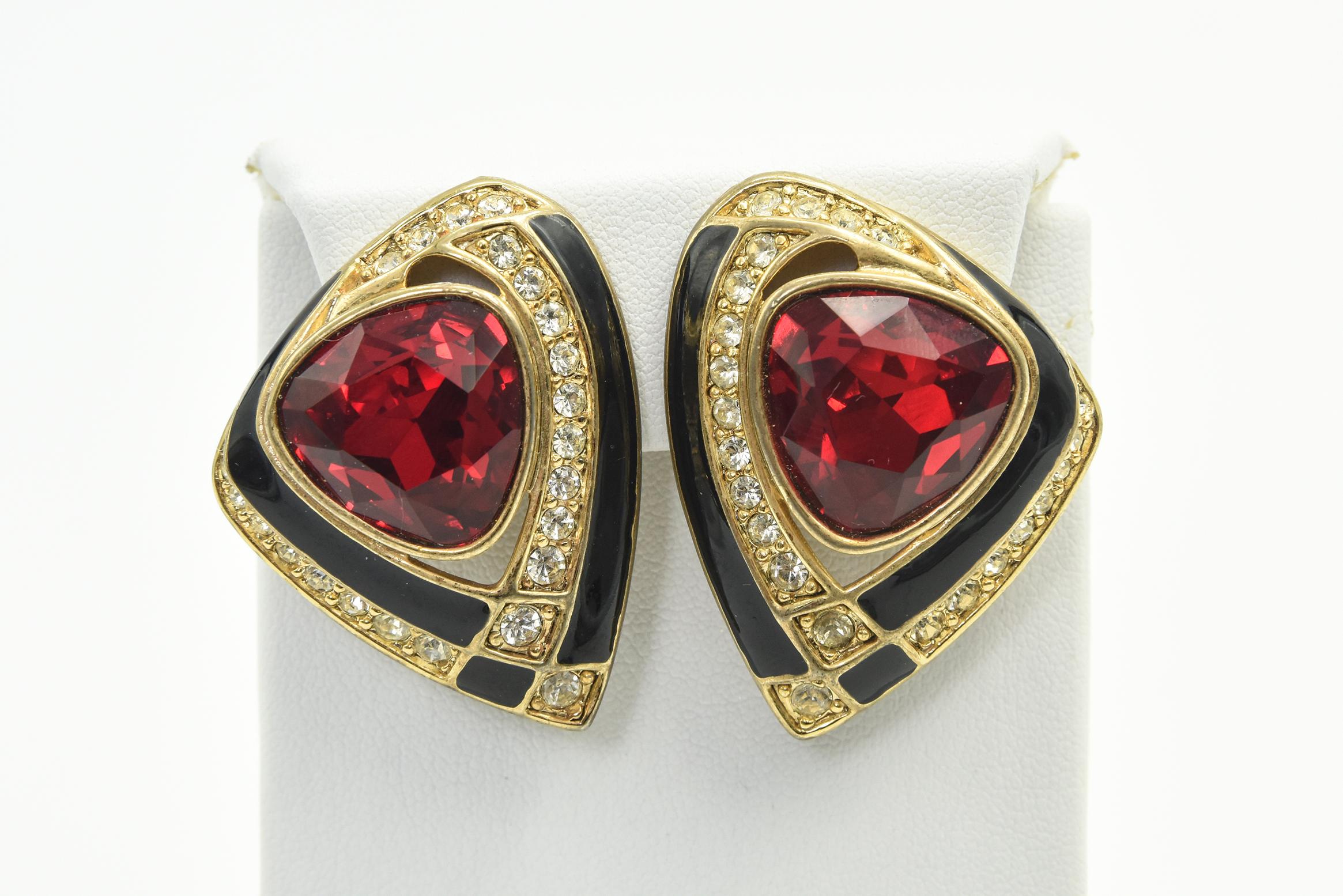 Large 1980s gold tone clip on earrings featuring a black enamel ribbon with a large red rhinestone in the center and white prong set rhinestones ribbon as well.  Signed Craft for Gem Craft.