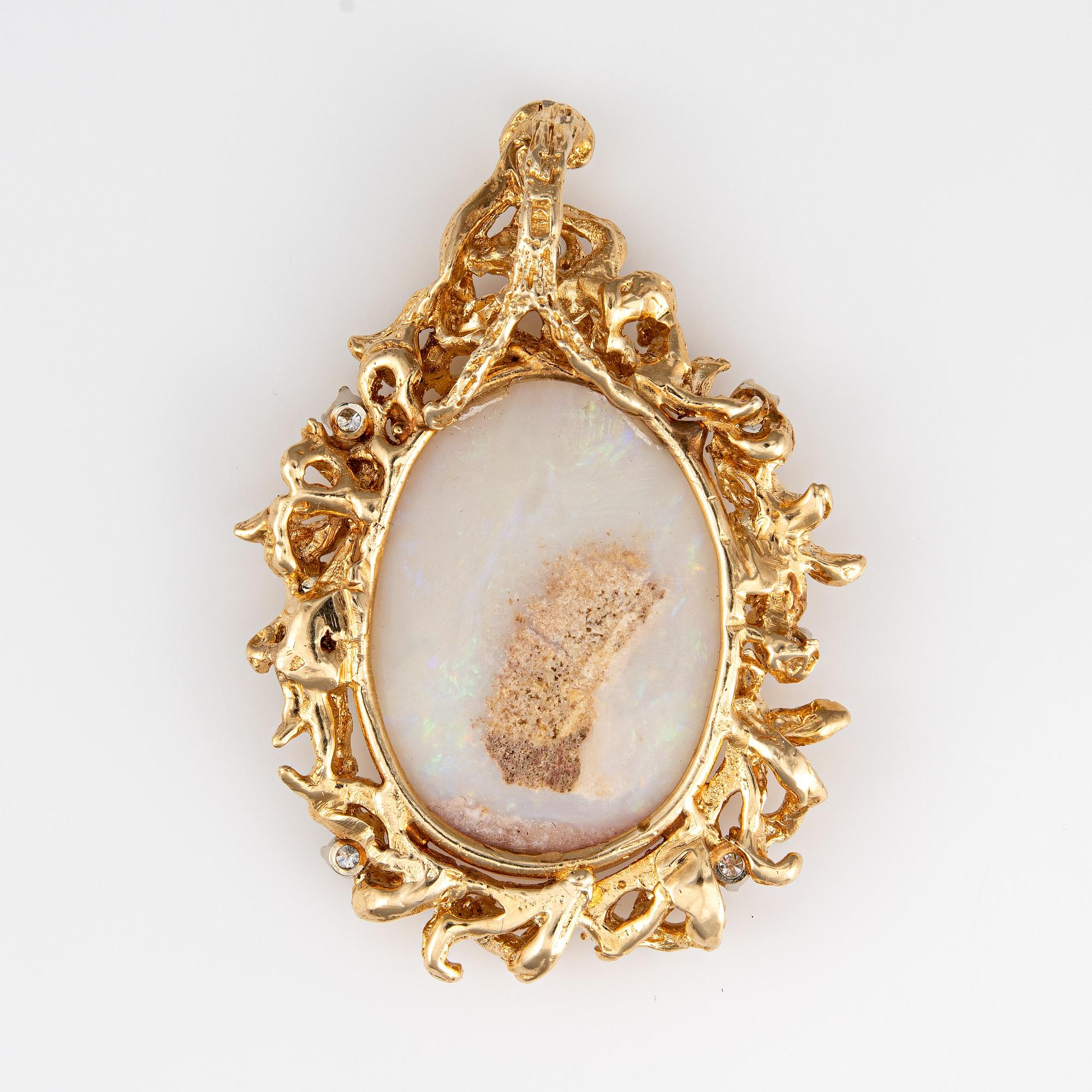 Finely detailed vintage opal & diamond pendant crafted in 14 karat yellow gold (circa 1970s). 

Cabochon cut opal measures 29mm x 21mm (estimated at 19 carats), accented with an estimated 0.75 carats of diamonds (estimated at G-H color and VS2-SI1