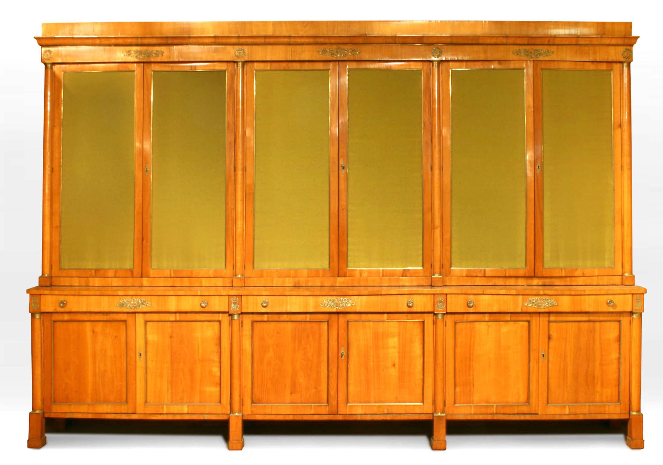 Austrian Biedermeier large (19th Century) cherrywood and brass trimmed 12 door cabinet with column sides and fabric in top doors.
