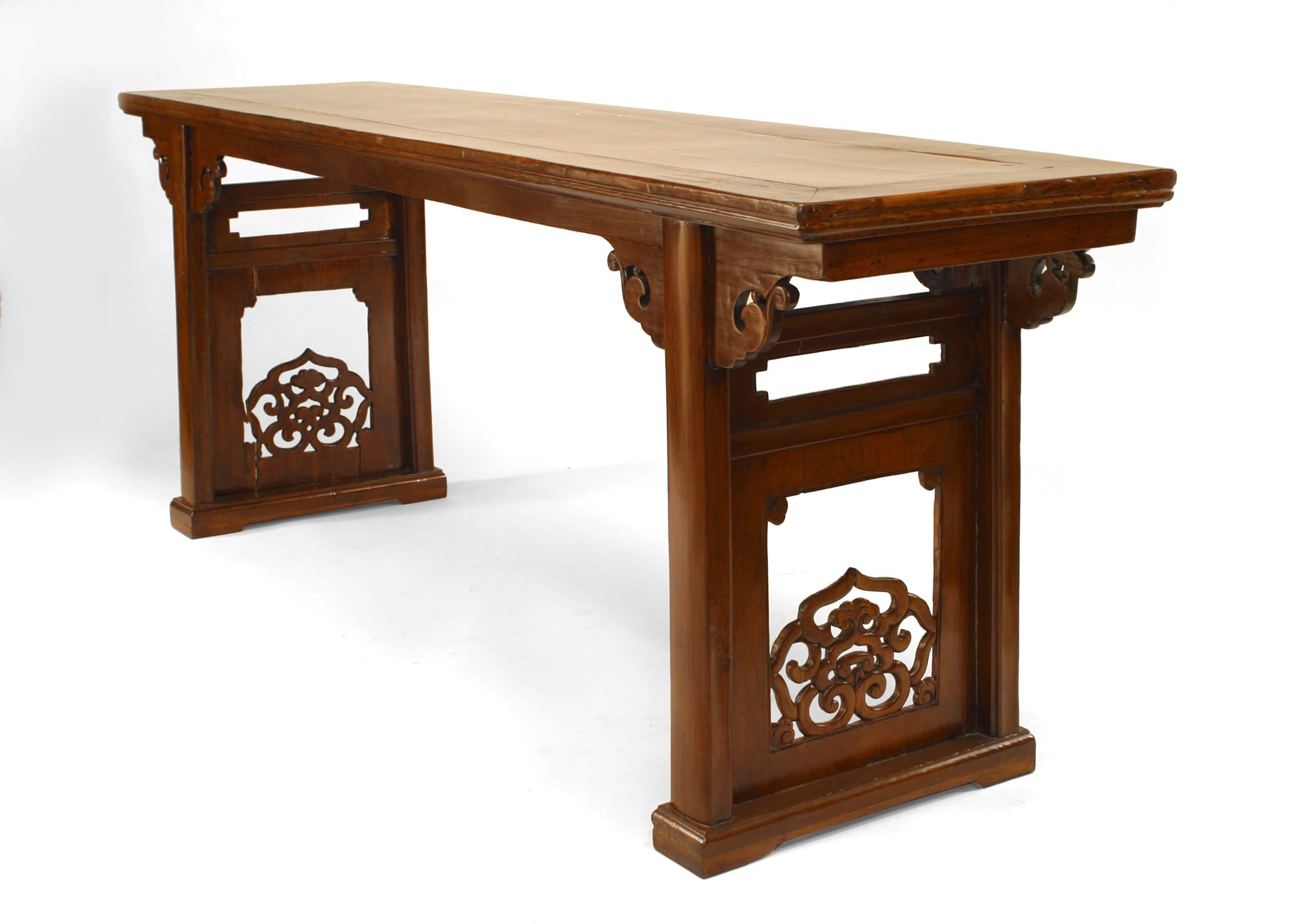 Chinese (19th Century) elmwood (yu-mu) large console table with carved cloud form scrolls between the legs on the apron and filigree carving with a stretcher on the sides.
