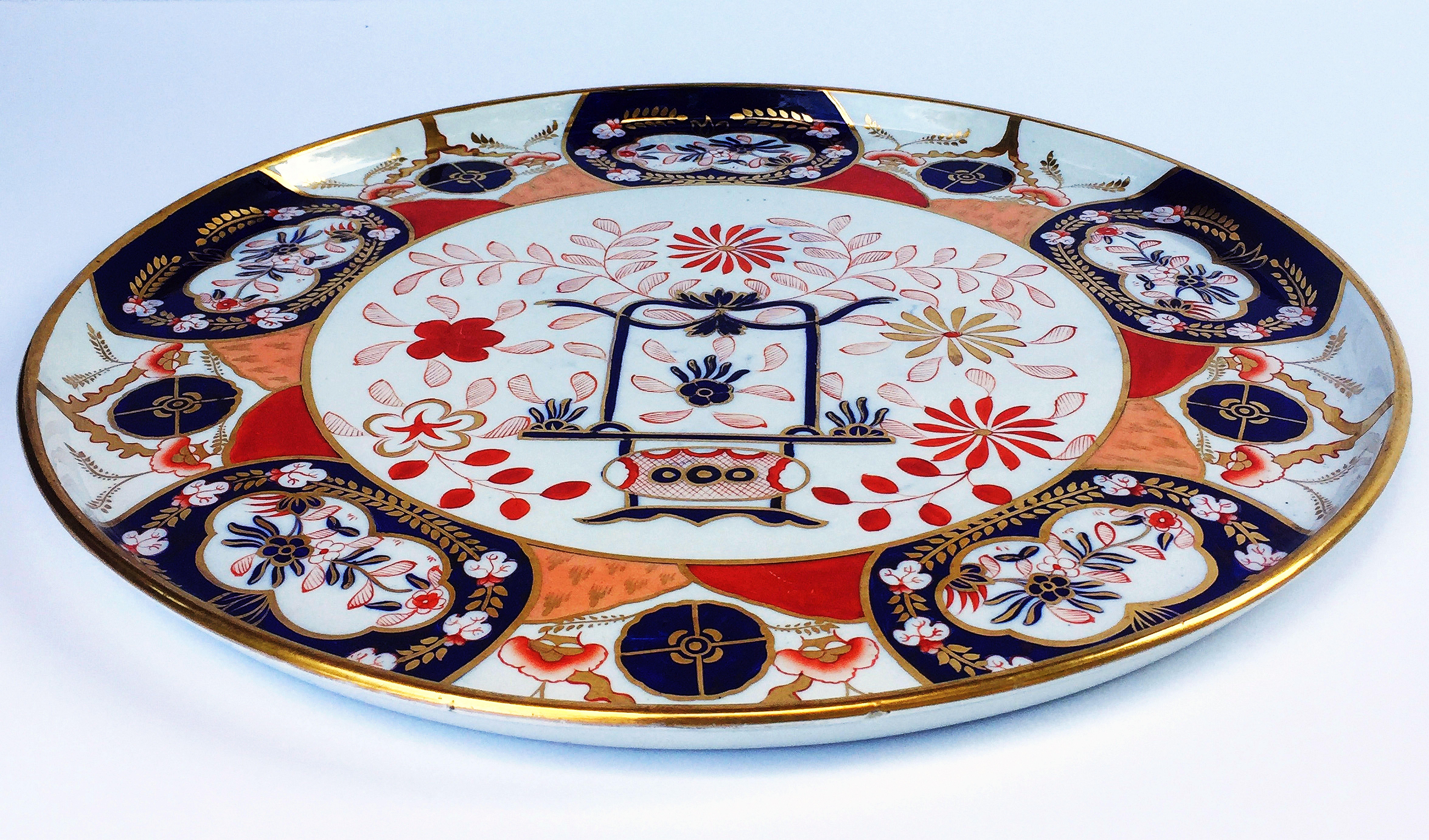 A large English Imari polychrome charger or round tray with raised edge around the circumference by the celebrated pottery firm, Copeland, c 1850 -1867, featuring a stylized Japonisme foliate design in blues and reds with gilt accents.

Impressed