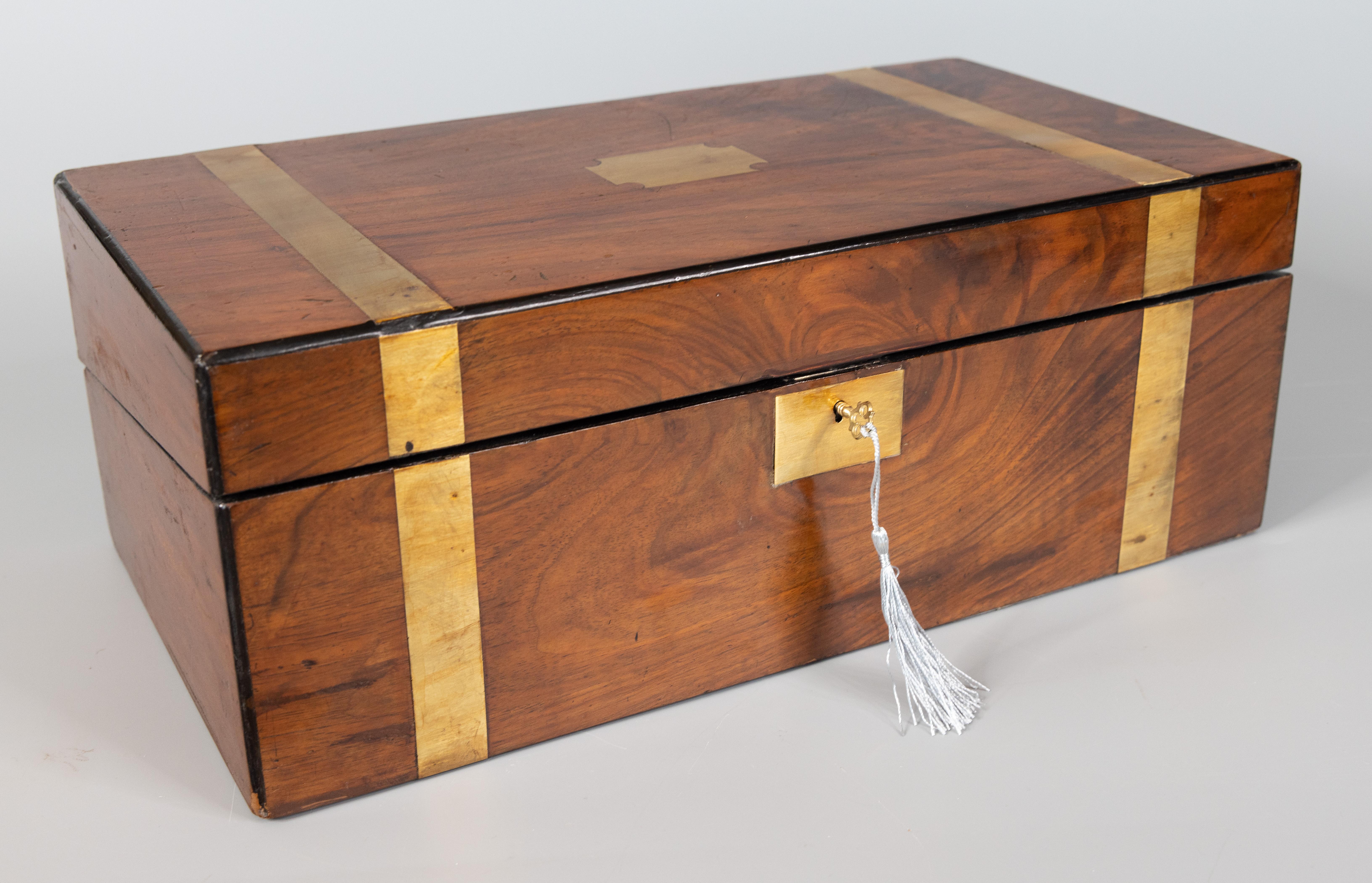 A very large antique English figured walnut campaign style box with lock and key, circa 1870. This fine hand crafted box has a richly figured walnut grain and is accented with brass bands, center and key plate. It is a nice large size at 18