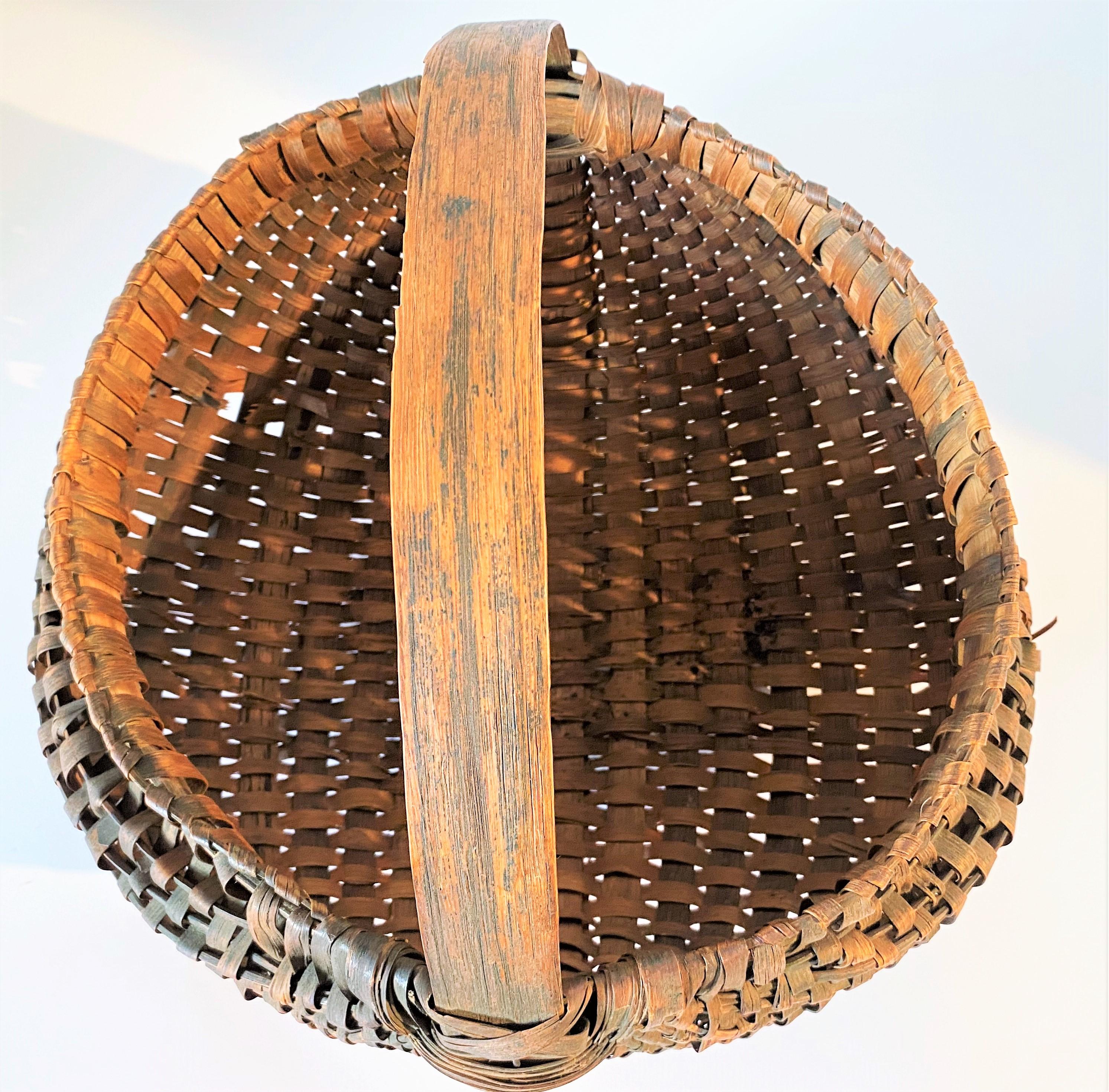 Large 19th C hand woven buttocks handled basket from New England.