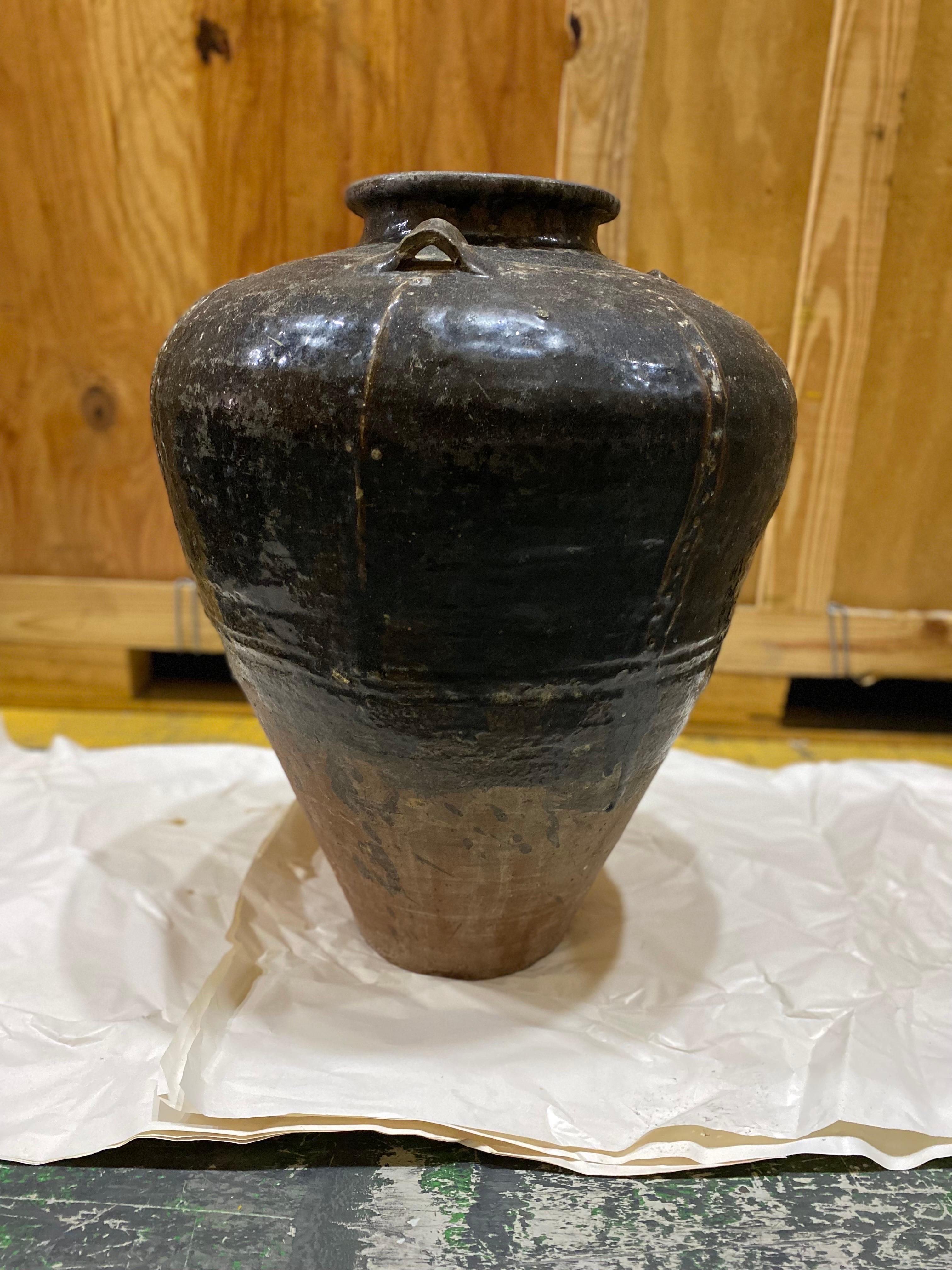 Un grand pot japonais du 19e siècle en terre cuite vernissée brune.
Une glaçure sombre sur une terre cuite partiellement non glacée. Un design intéressant et inhabituel qui ressemble à un travail de métal japonais. Bon état général. Une certaine