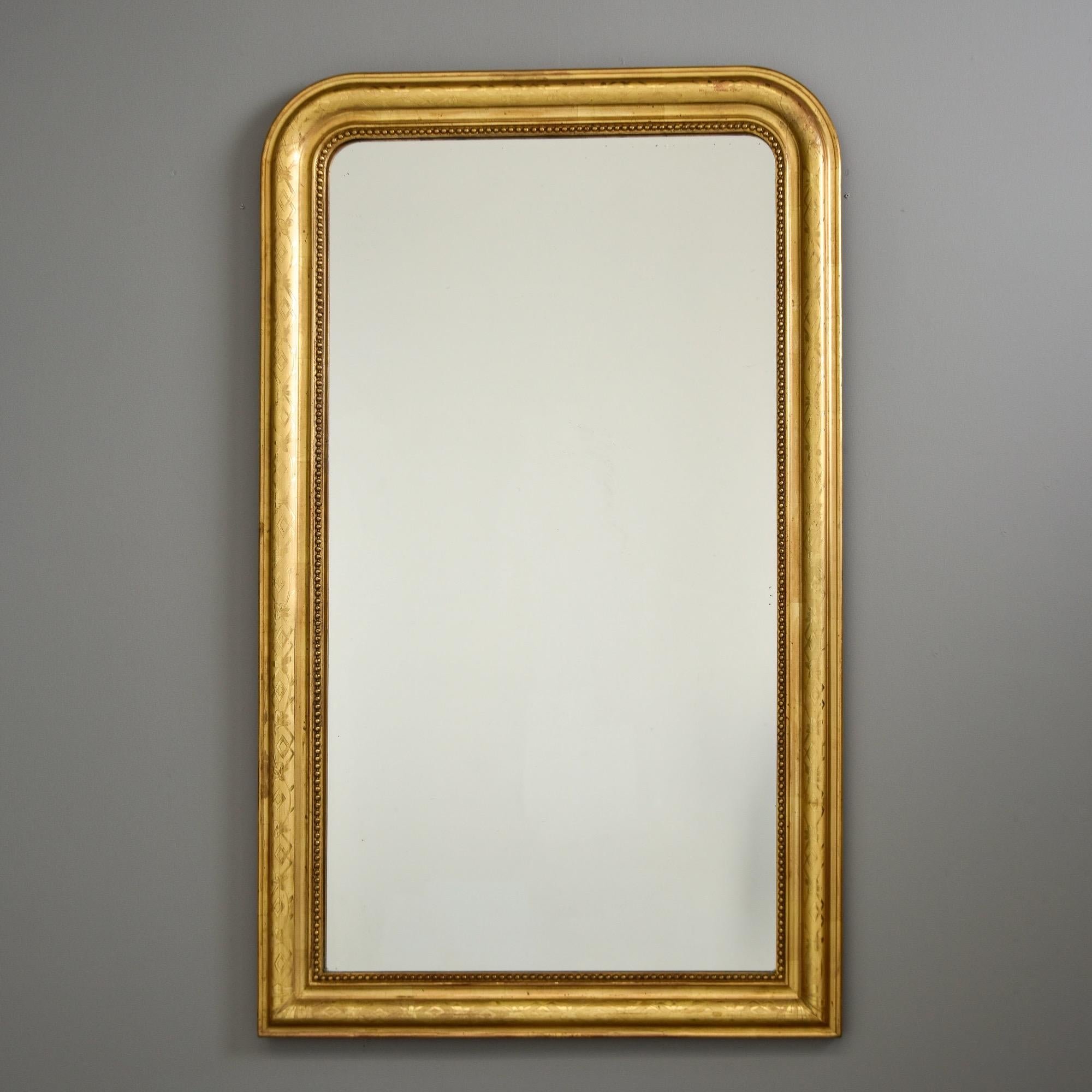 Trouvé en France, ce miroir Louis Philippe encadré de bois doré date des années 1870. Le miroir a été remplacé récemment - nous avons acquis cette pièce telle qu'elle est présentée auprès d'un marchand français. Subtil motif gravé sur tout le