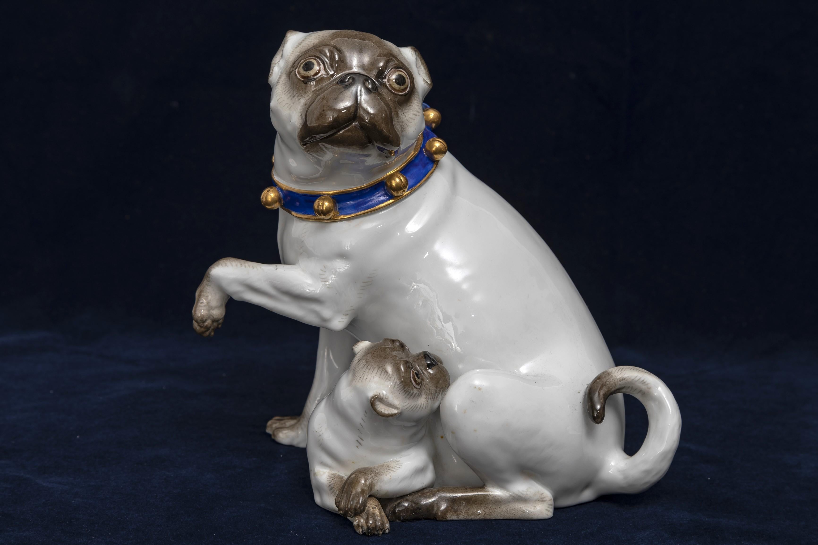 Grande figurine en porcelaine de Meissen du XIXe siècle représentant une mère carlin blanche et son enfant avec des clochettes dorées sur un collier bleu.  Ce grand modèle est très rare à trouver dans cette qualité, cet état et cette taille. Le