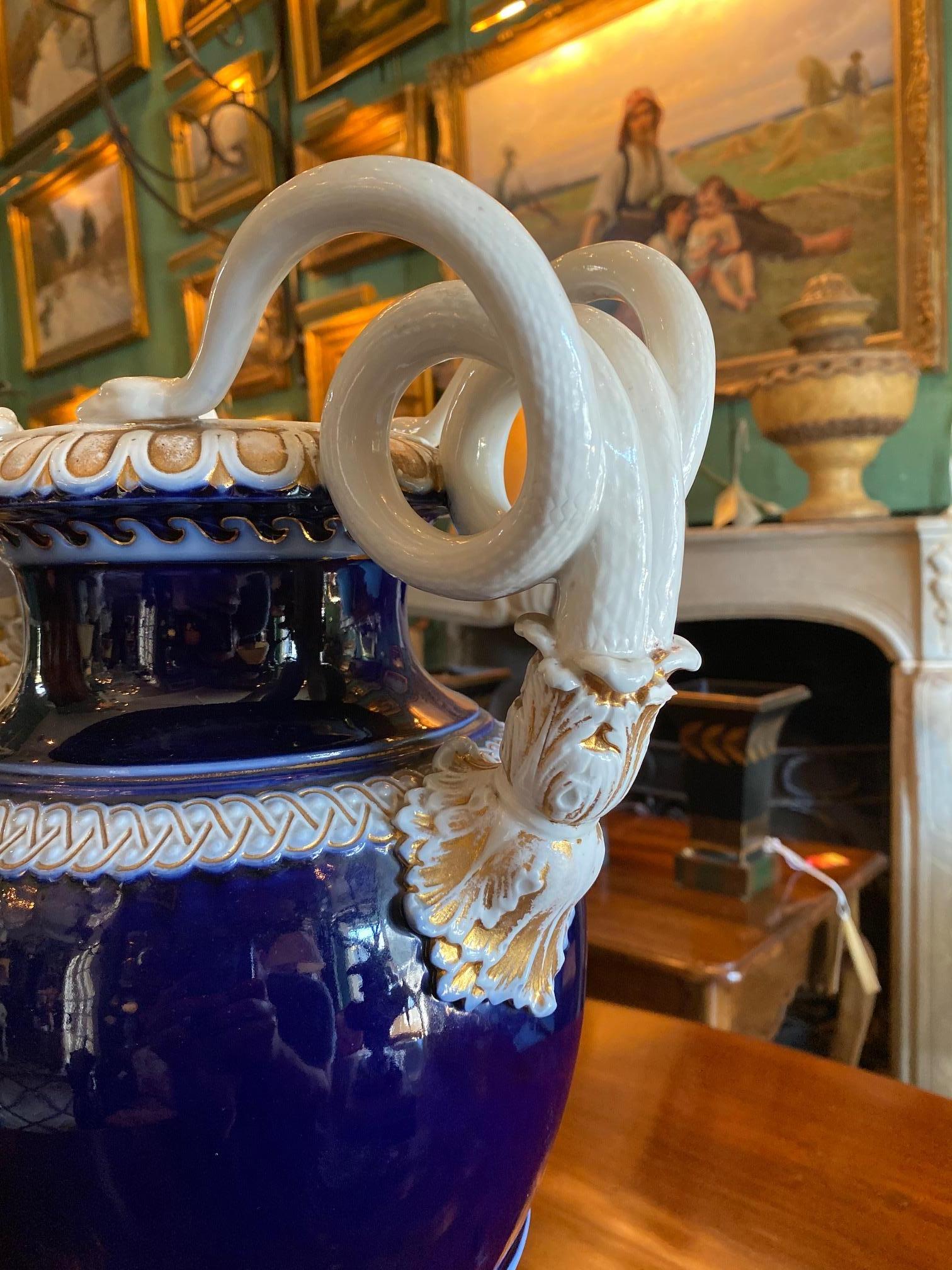 Large 19th century German hand painted gilt-trimmed Meissen porcelain vase urn. Snake handled cobalt blue vases
with gilt trim and scroll handles. Vase in the form of an urn. The vase highlighted with gilt decoration and with elaborate serpent