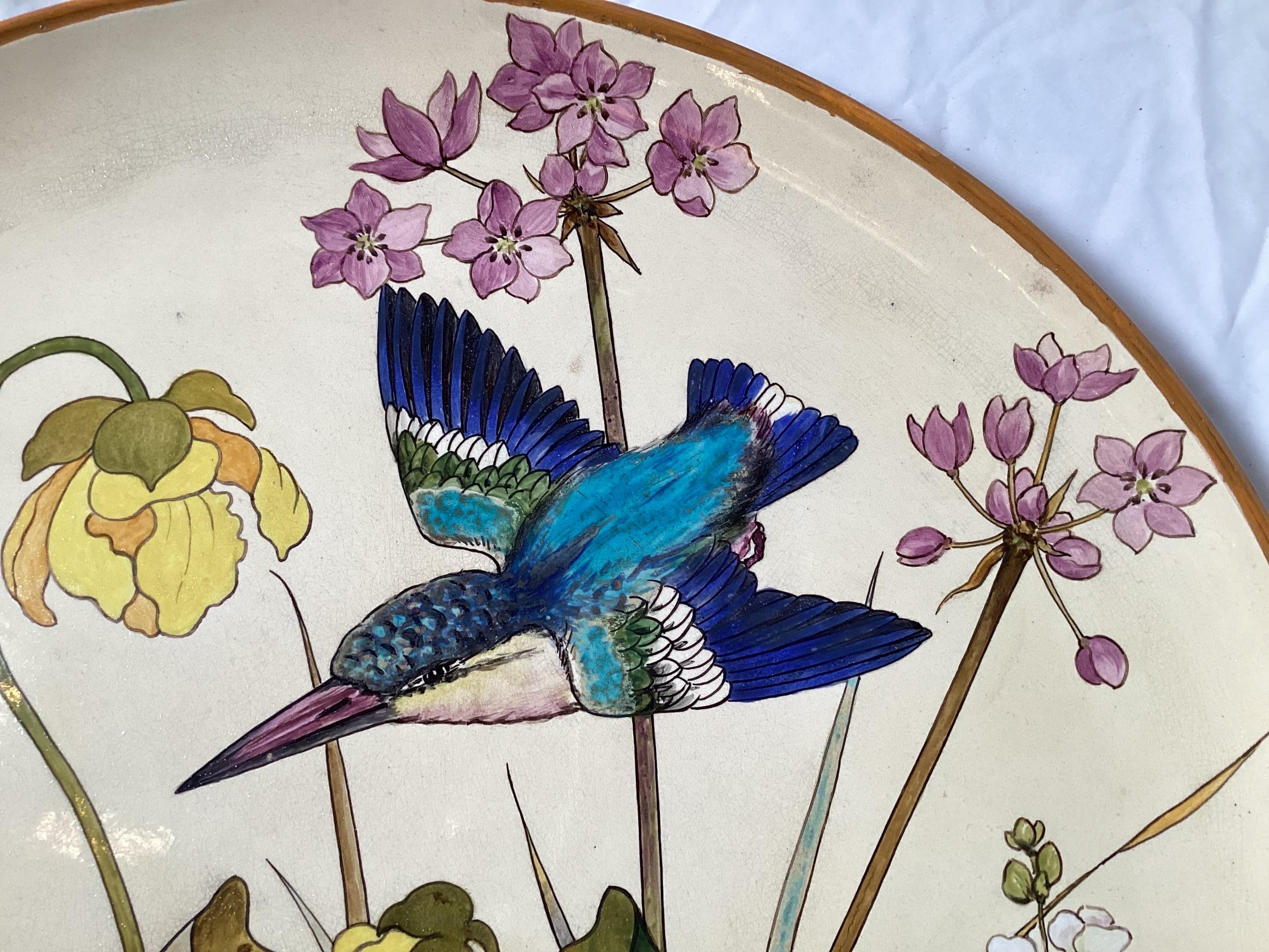A large and beautiful hand painted charger, England, Aesthetic Movement, by Minton. The charger is 22.5 inches in Diameter with an impressed Minton mark and a black stamp Minton's Art Pottery . Decorated with dogwood, leaves, birds a flowers. There