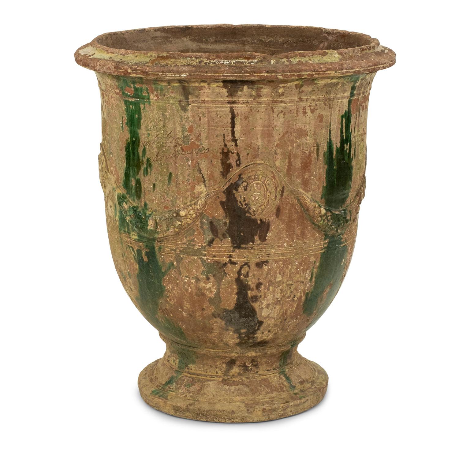 Large 19th century Anduze jar. Decorated in dark brown and green drip glaze and adorned with swag decoration in raised relief. Signed and dated by artist (1820) with the Boisset mark in cartouche. Some chipping at base and rim consistent with age