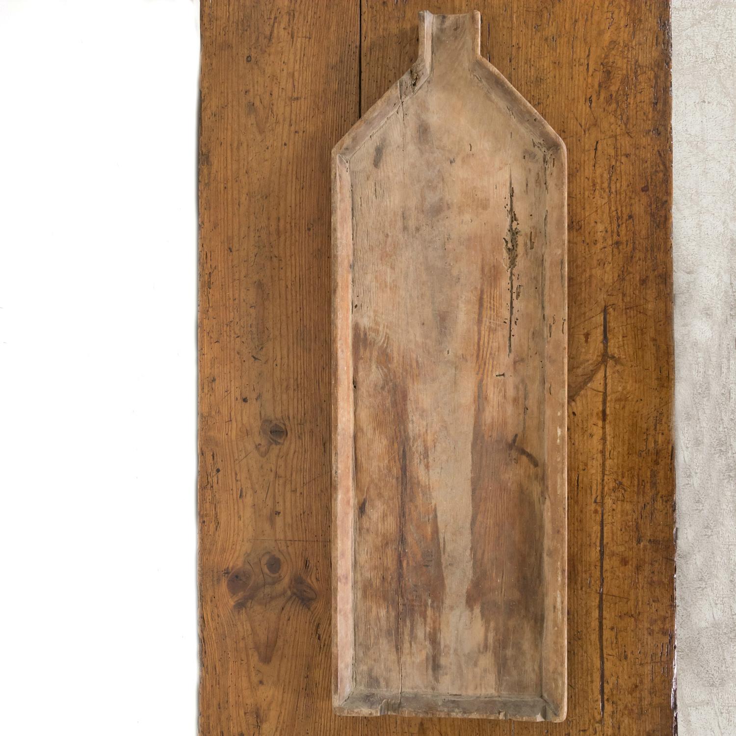 A large 19th century French cheese board from the Normandy region of France, circa 1870s. Having a timeworn patina that happens only after decades of use, this antique cheese board with raised edges was used by a cheese maker as he worked the cheese