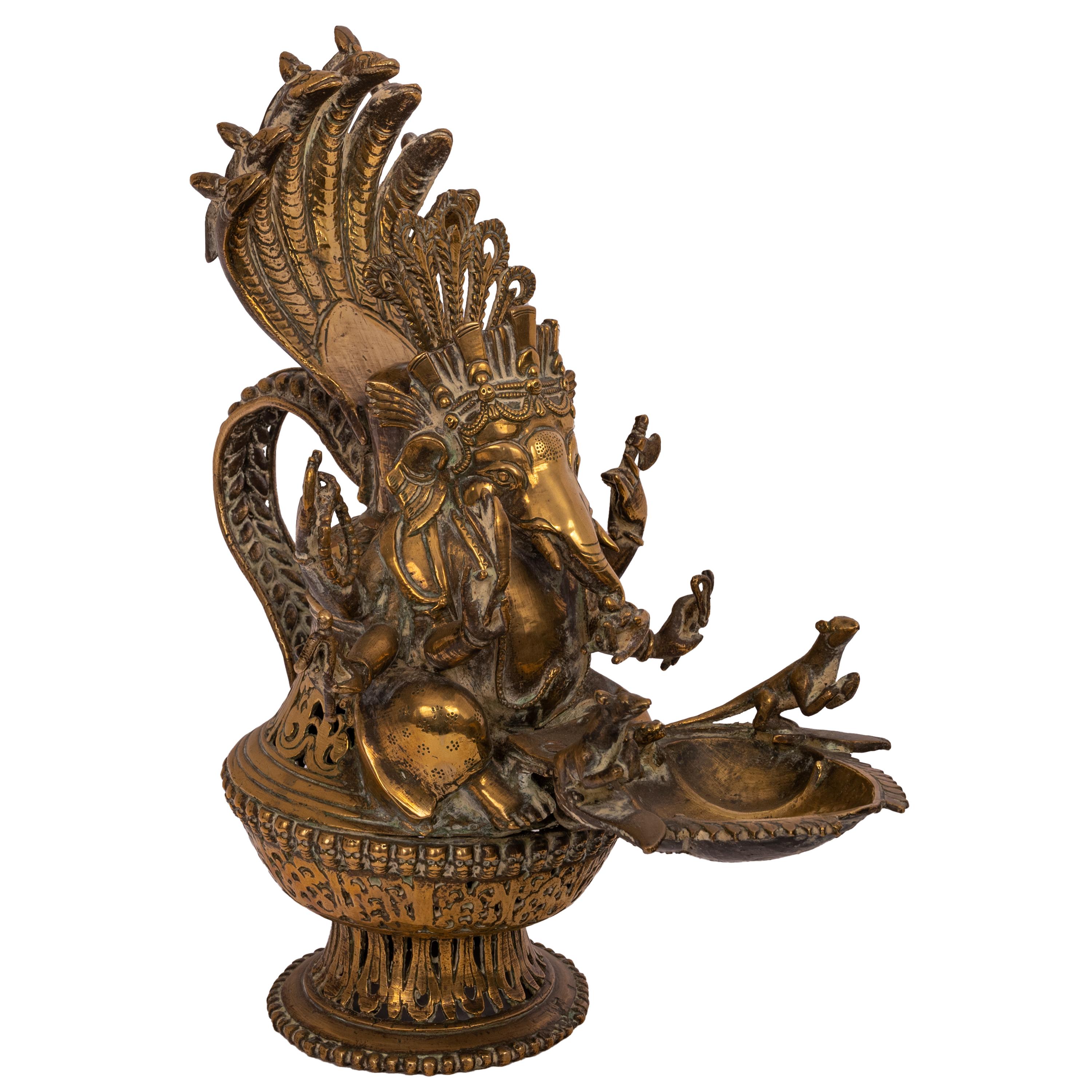 A large antique early 19th century Indian brass votive oil lamp modeled as the Hindu deity, Lord Ganesha, circa 1800.
A finely cast brass figure of Lord Ganesha with a crown of snakes and four arms, the head of Ganesha having a hinged lid to fill