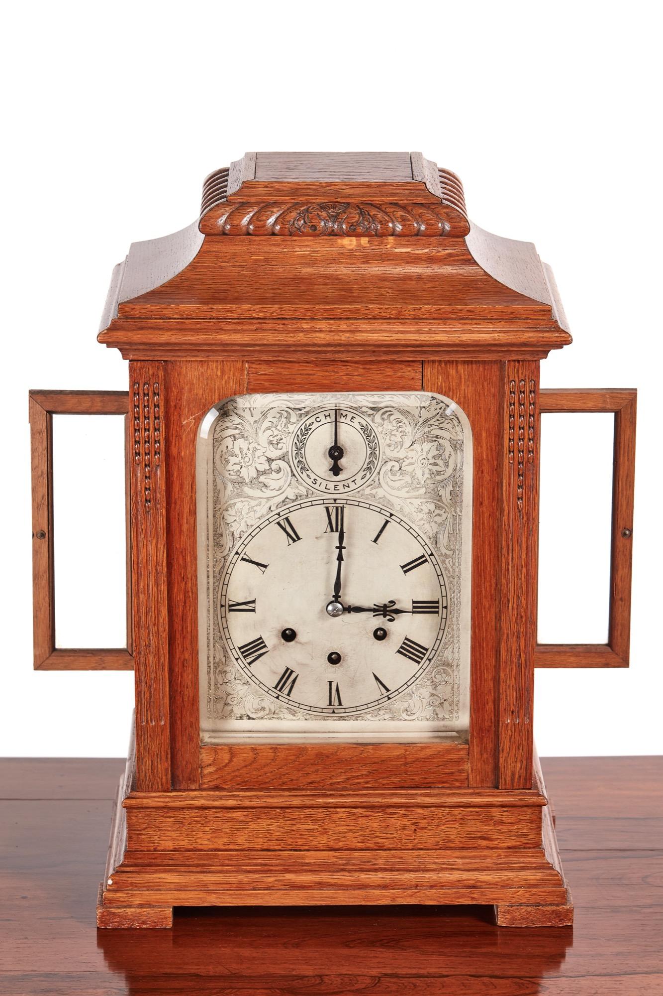 This is a large 19th century antique oak 8 day bracket clock with engraved roman silvered chapter ring with chime/silent dial and 8 day three train movement. It has a beautifully carved oak case. It stands on a shaped base. It is in good working